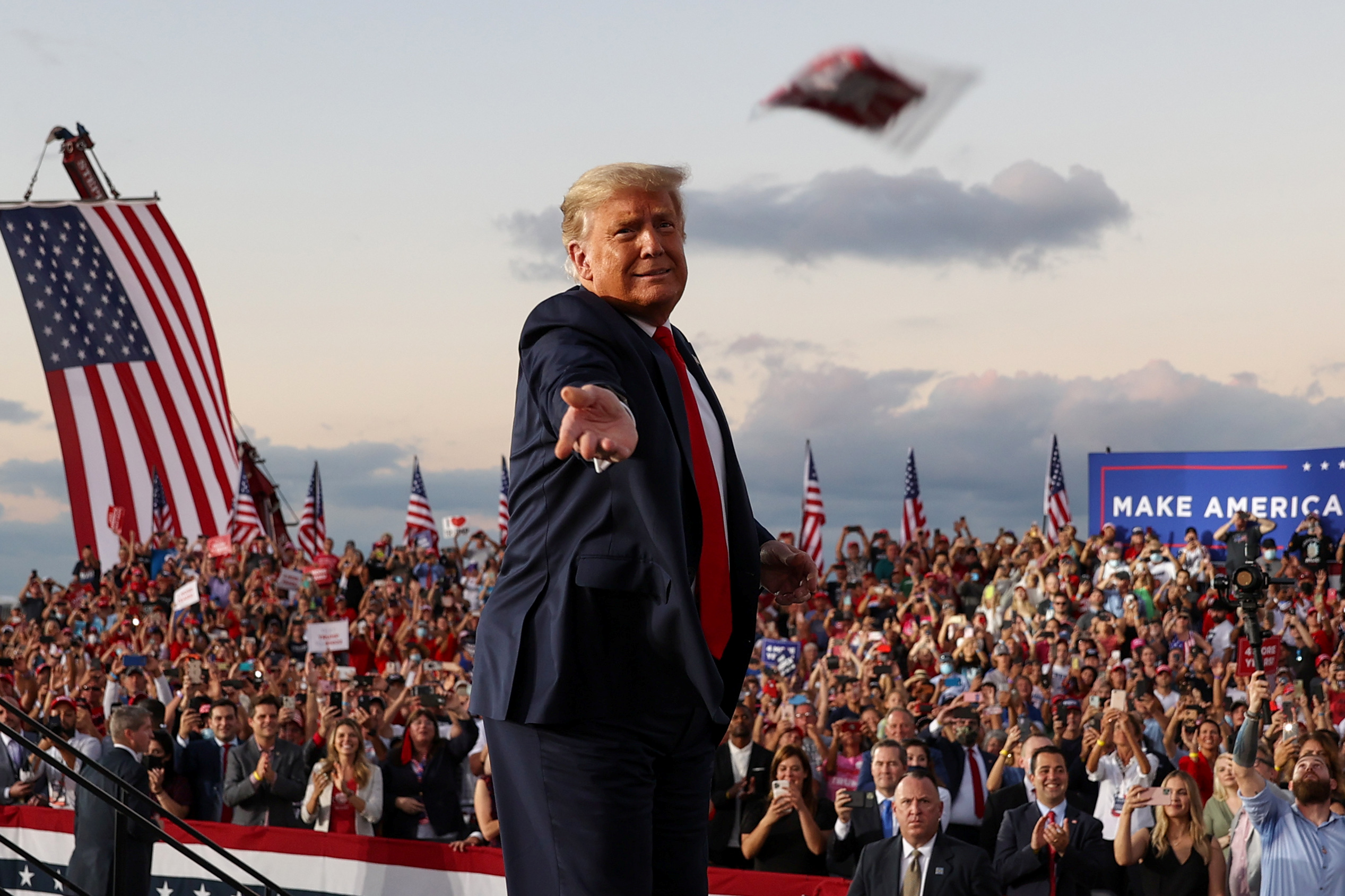 US President Donald Trump tosses a face mask to the crowd as he takes the stage for a campaign rally, his first since being treated for the coronavirus disease, at Orlando Sanford International Airport in Sanford, Florida, US