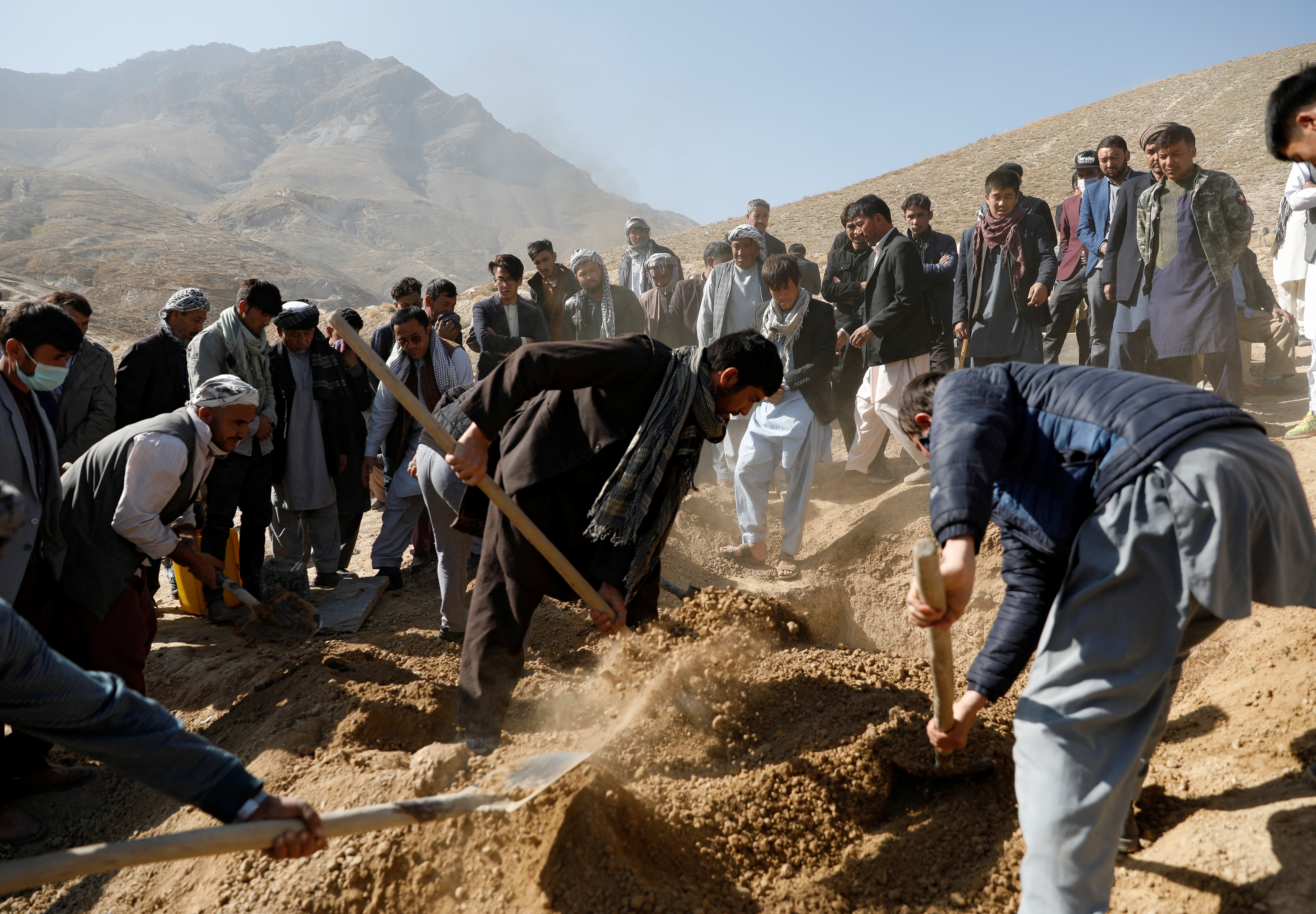 Afghan men take part in a burial ceremony for one of the victims, who was killed in yesterday’s suicide bombing in Kabul