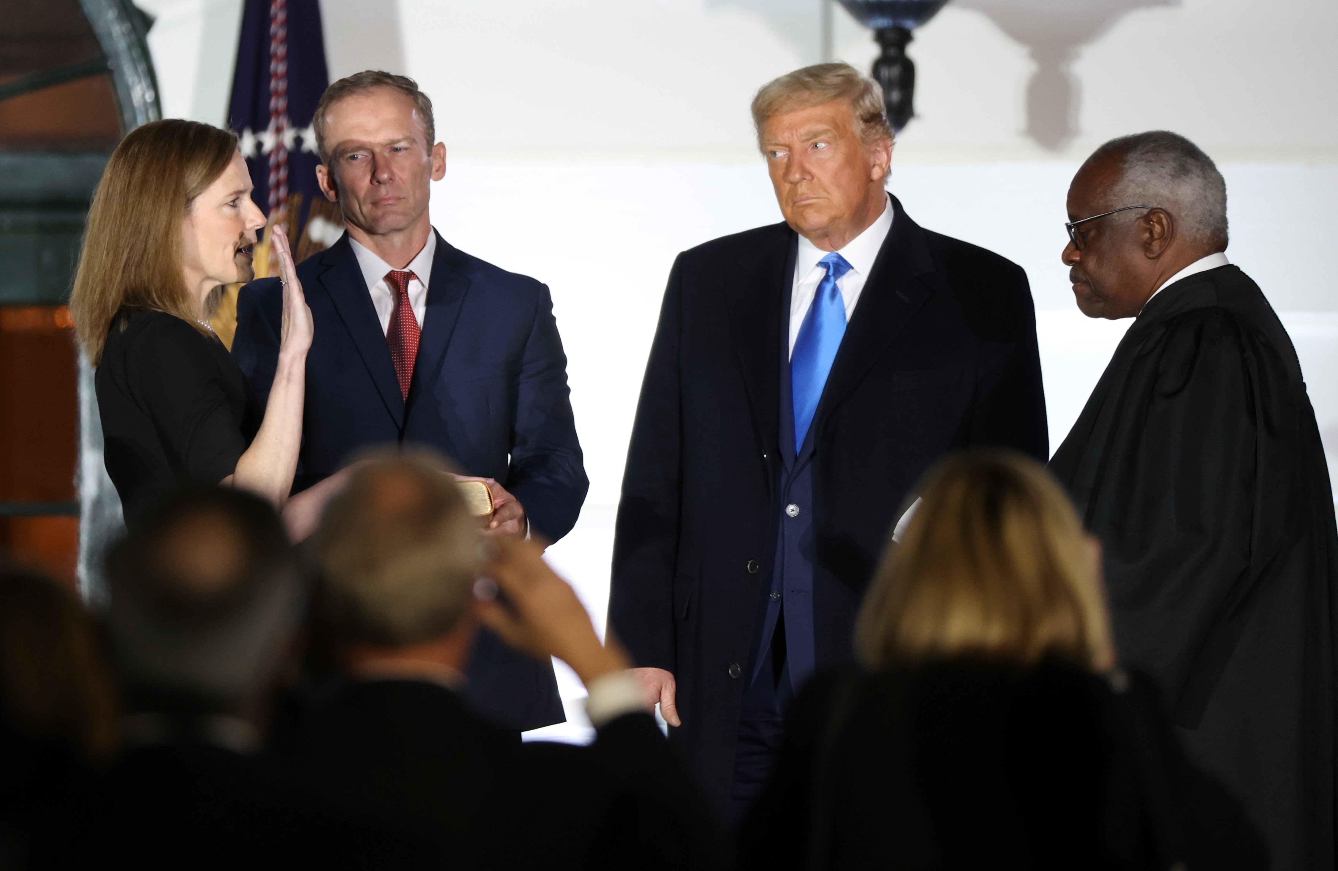Judge Amy Coney Barrett is sworn in as an associate justice of the Supreme Court by Justice Clarence Thomas as her husband Jesse Barrett and President Donald Trump watch