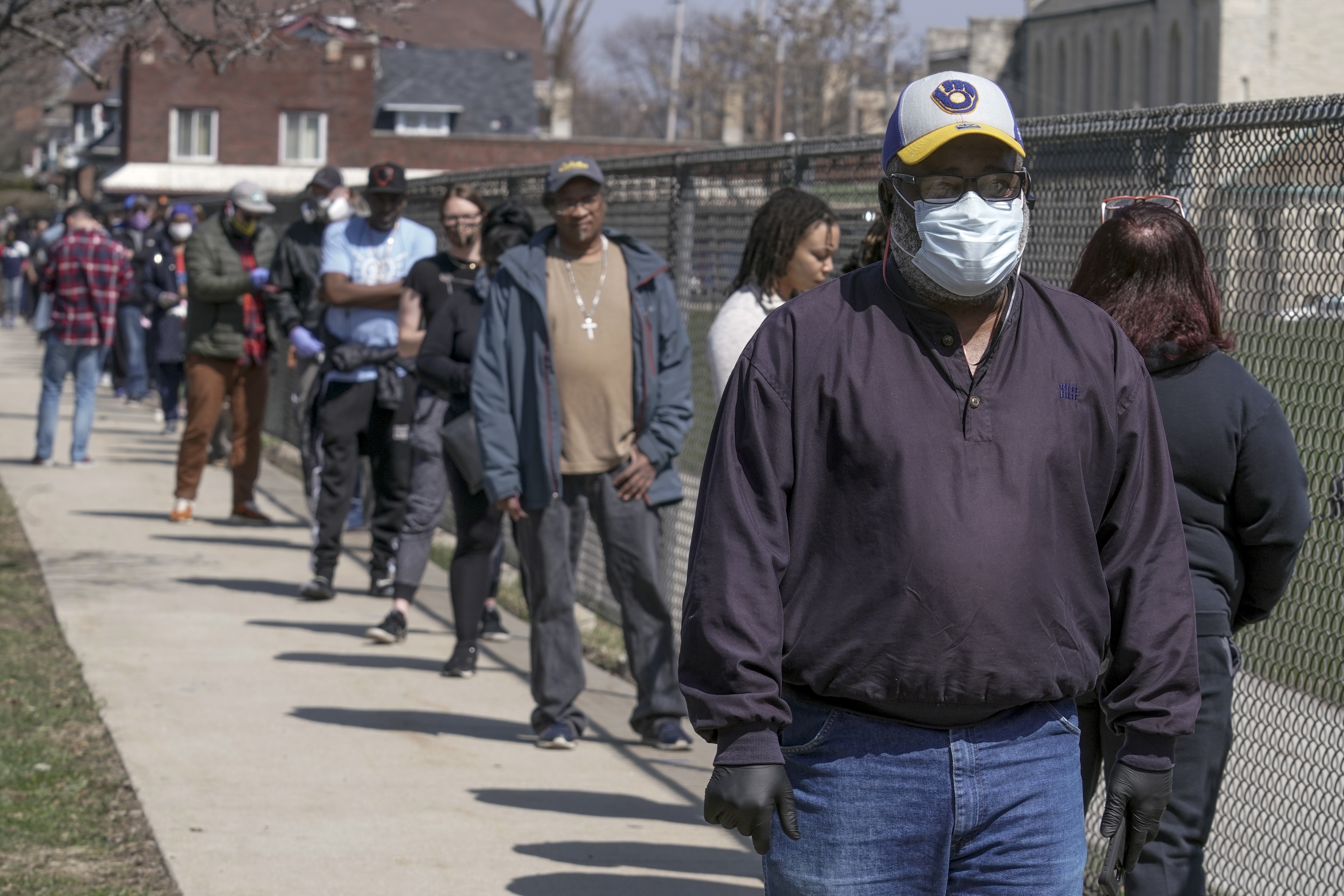 Voters observe social distancing guidelines as they wait in line to cast ballots in the presidential primary election in Milwaukee, Wisconsin, on April 7, 2020