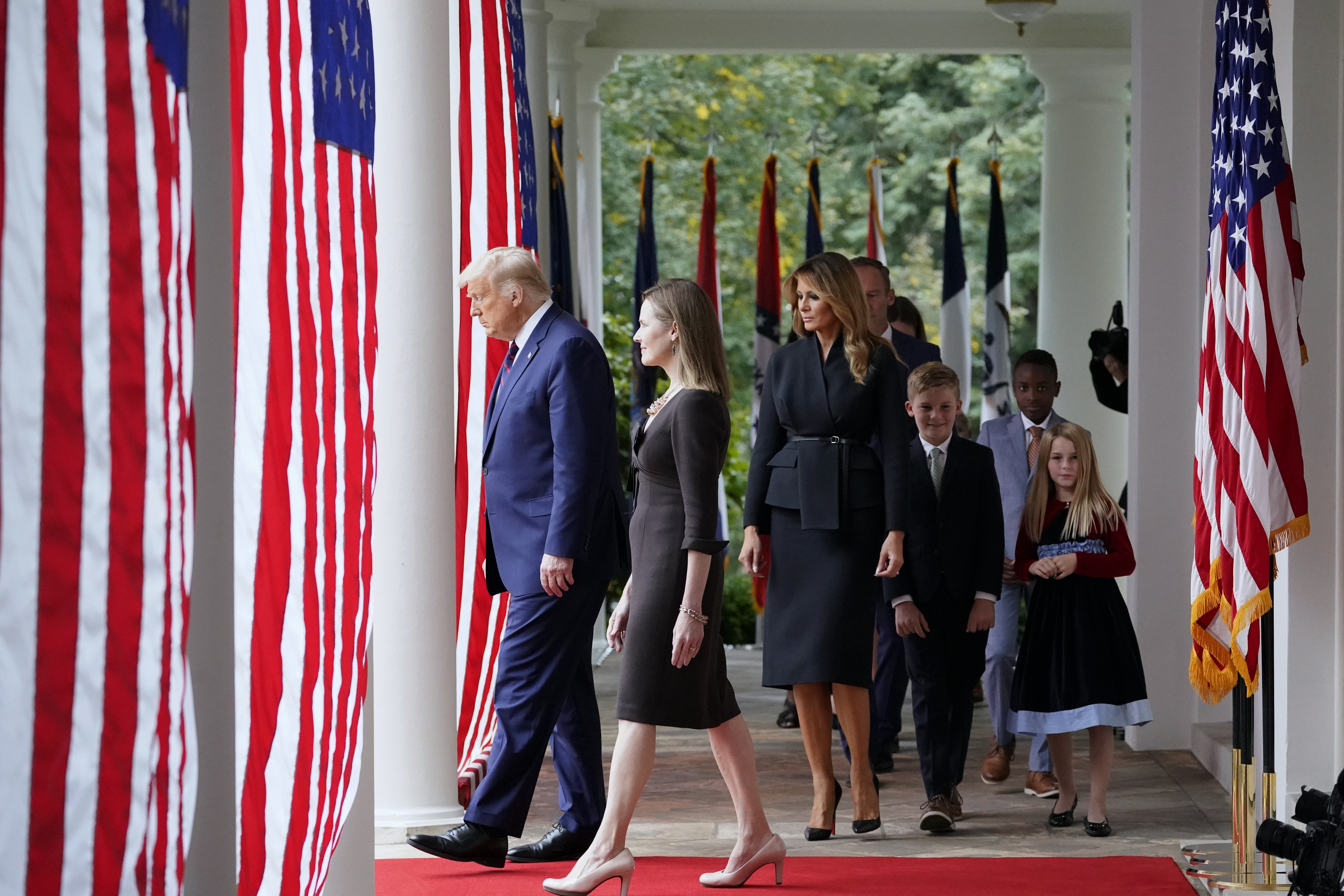 President Donald Trump walks along the White House Colonnade with Judge Amy Coney Barrett to a news conference to announce Barrett as his nominee to the Supreme Court on September 26, 2020