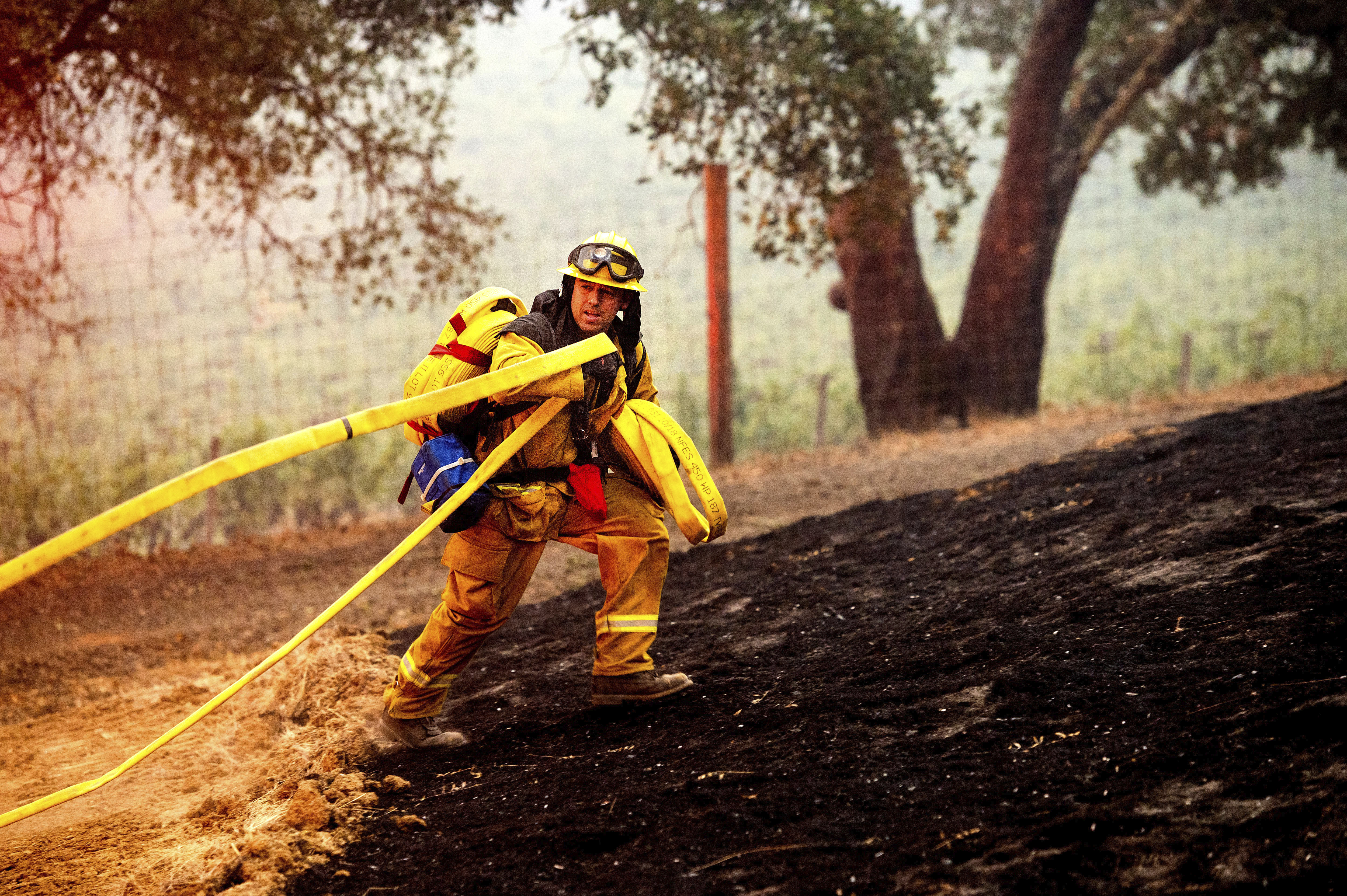 A firefighter battles the Glass Fire burning in a Calistoga, California, vineyard