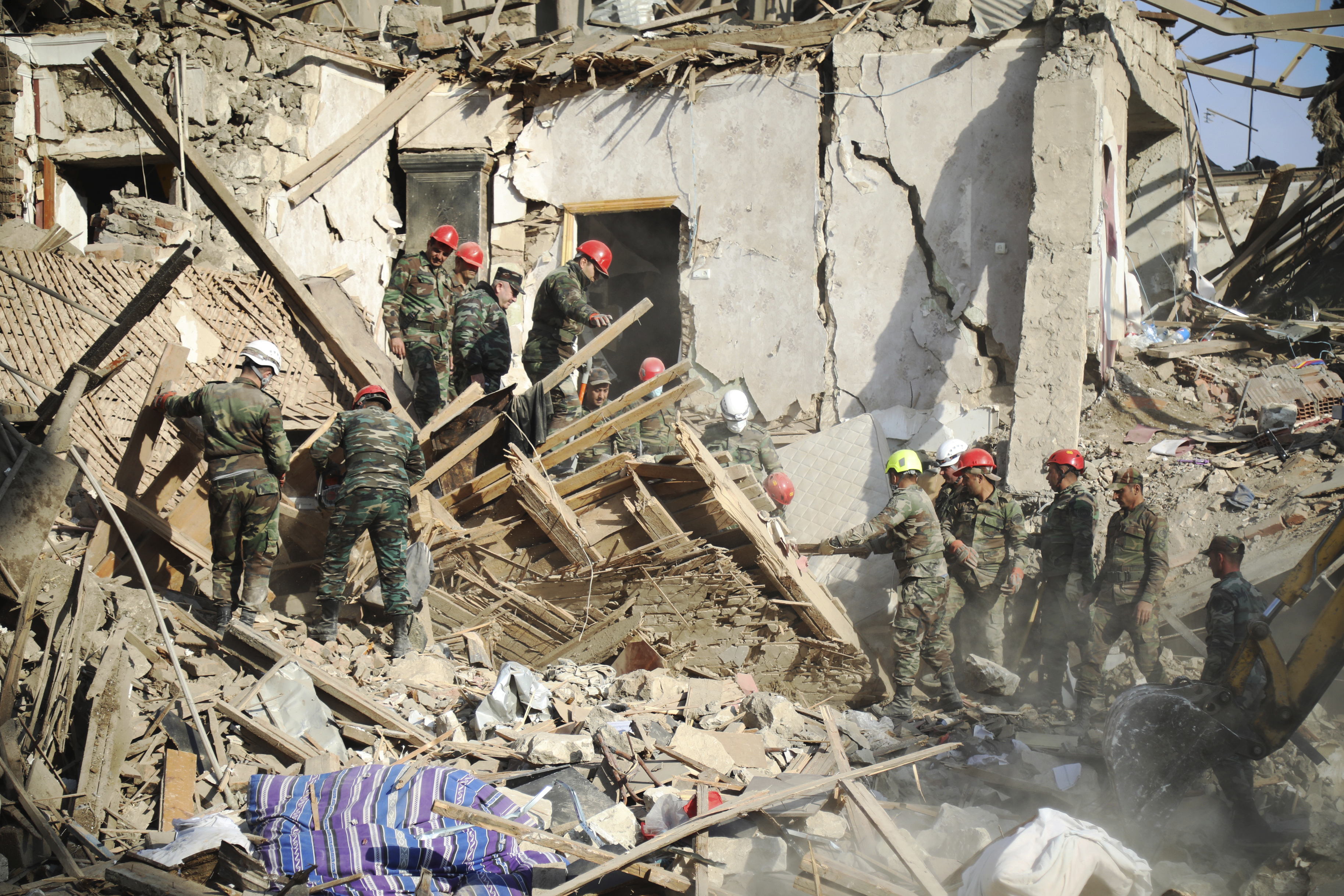 Rescuers work at the scene of damage after shelling hit Ganja, Azerbaijan