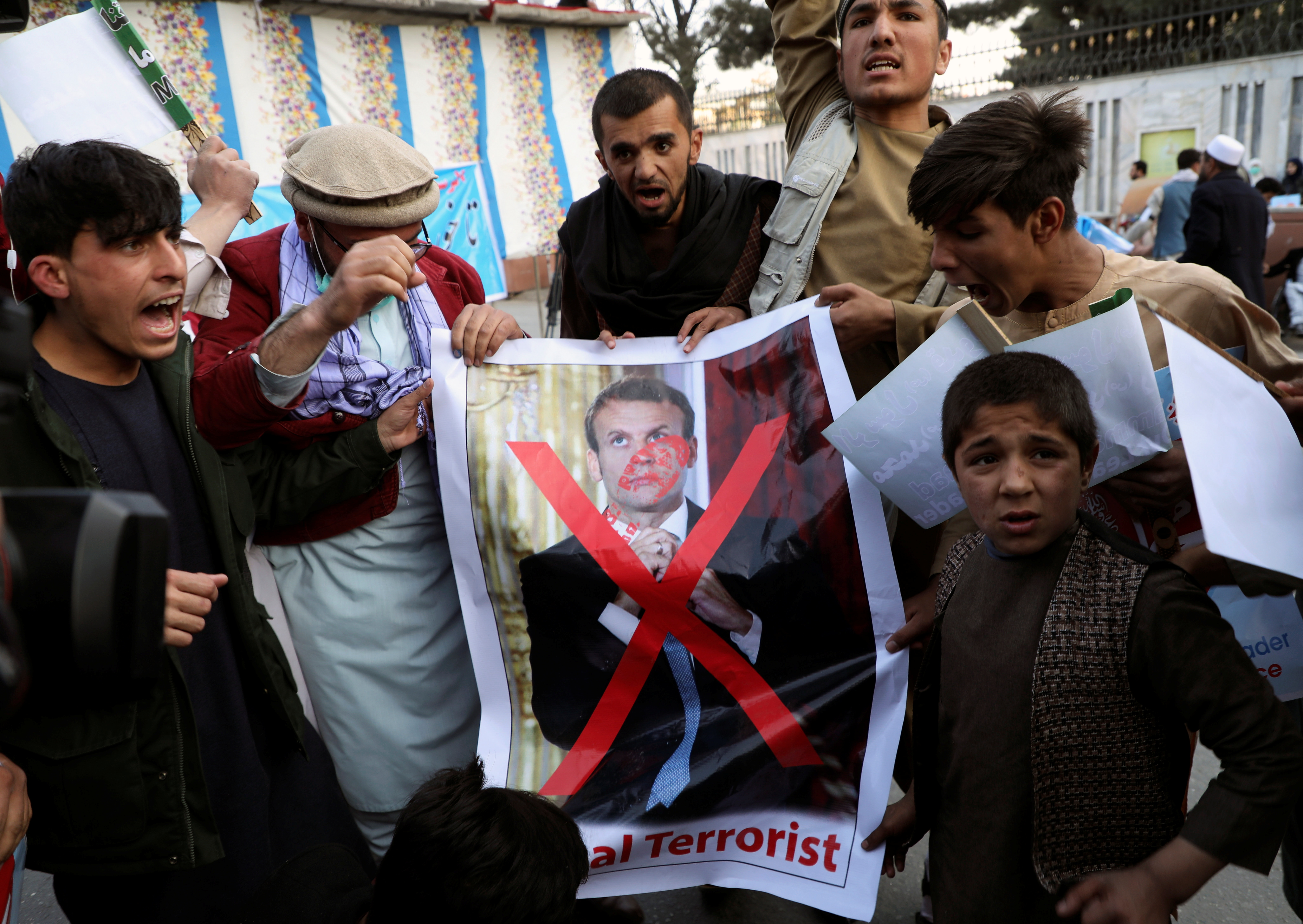 Protesters set fire to a poster of French President Emmanuel Macron in Kabul on Friday