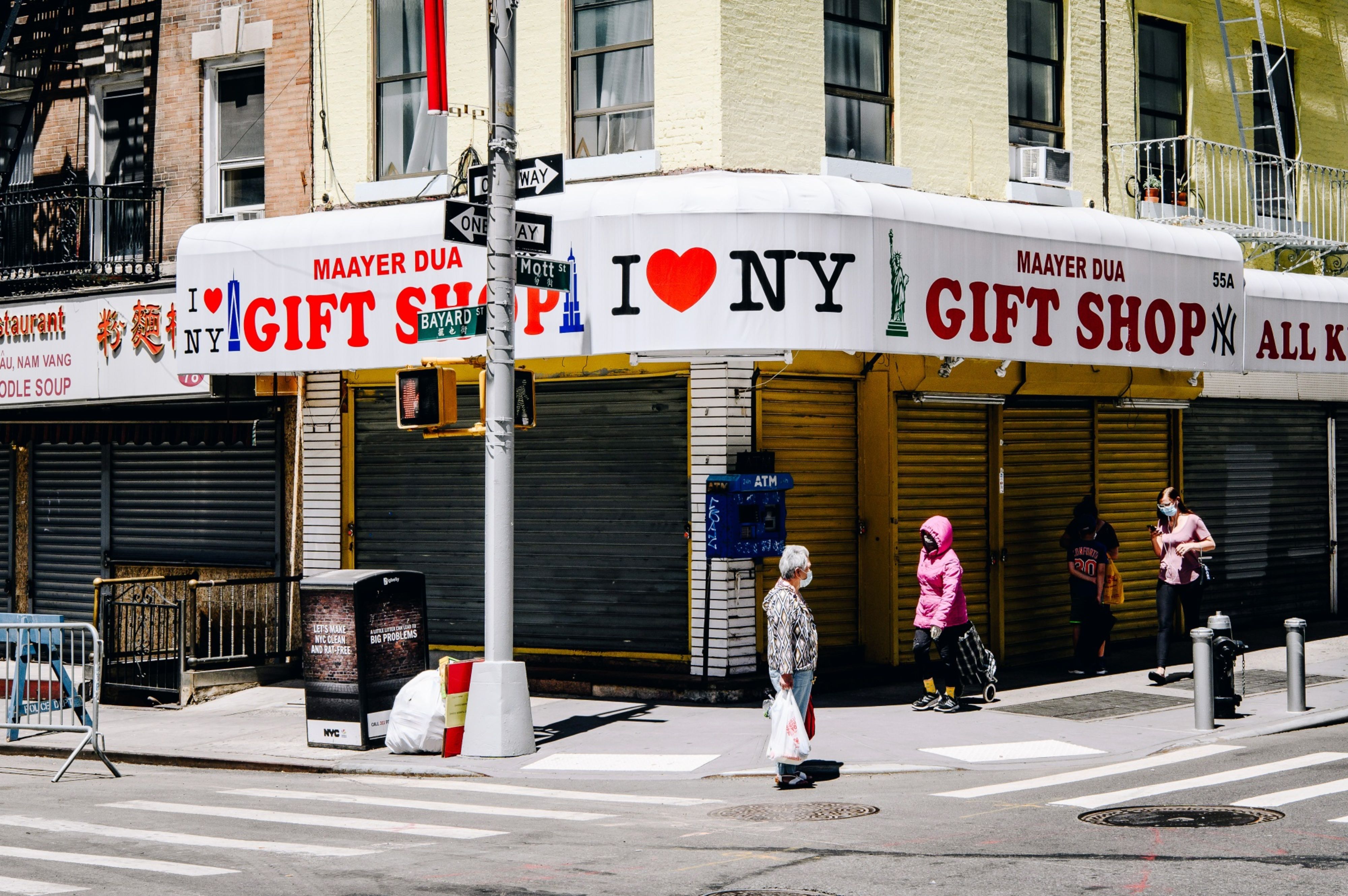 Pedestrians wearing protective masks walk through the Chinatown neighbourhood of New York City in the United States, where businesses are struggling to stay open