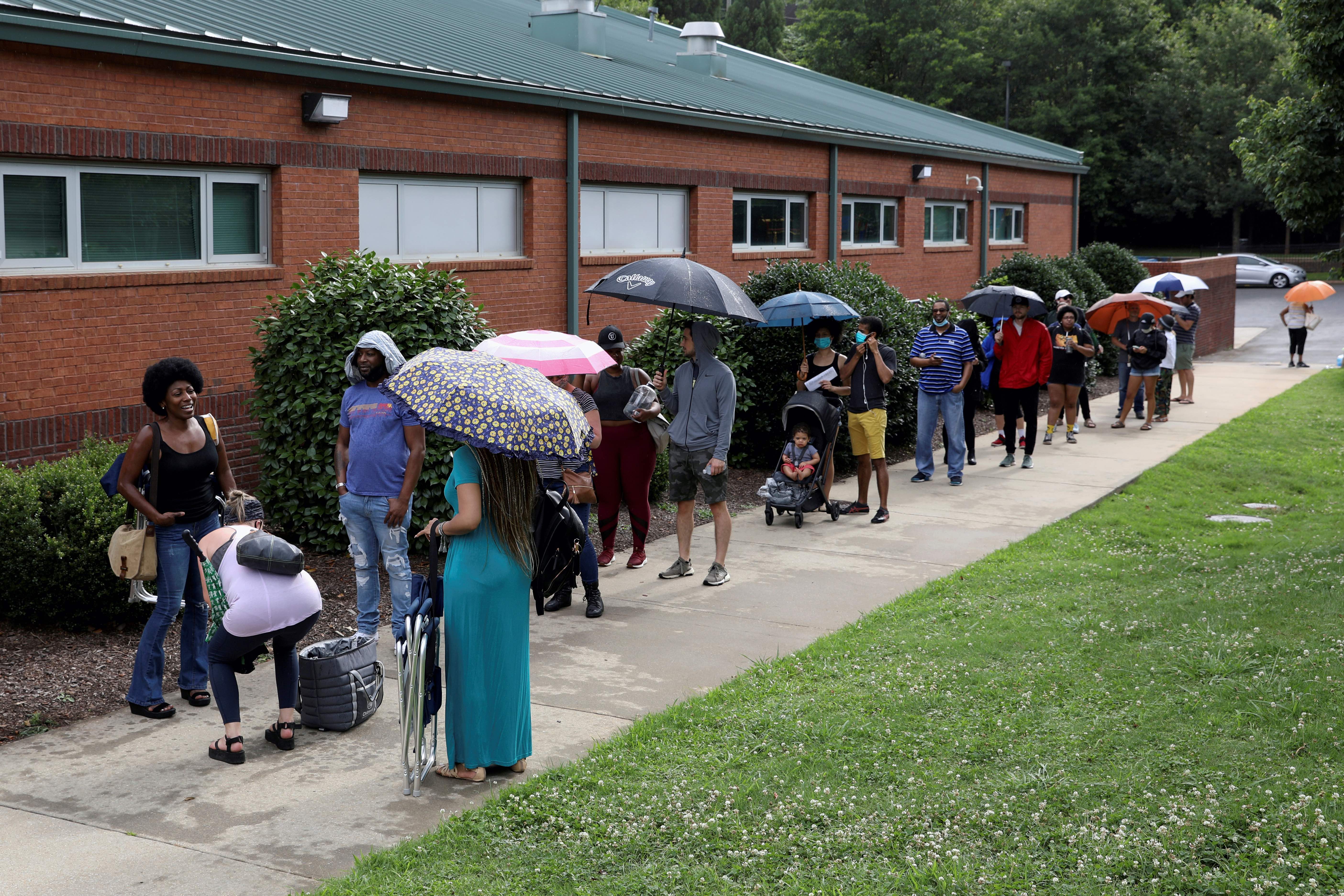 Voters line up to cast their ballots outside of a polling location after Democratic and Republican primaries were delayed due to the coronavirus restrictions in Atlanta, Georgia, United States