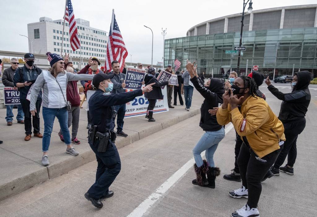 Counter-protesters gesture at supporters of US President Donald Trump during demonstrations outside of the TCF Center in Detroit, Michigan days before the 2020 presidential election