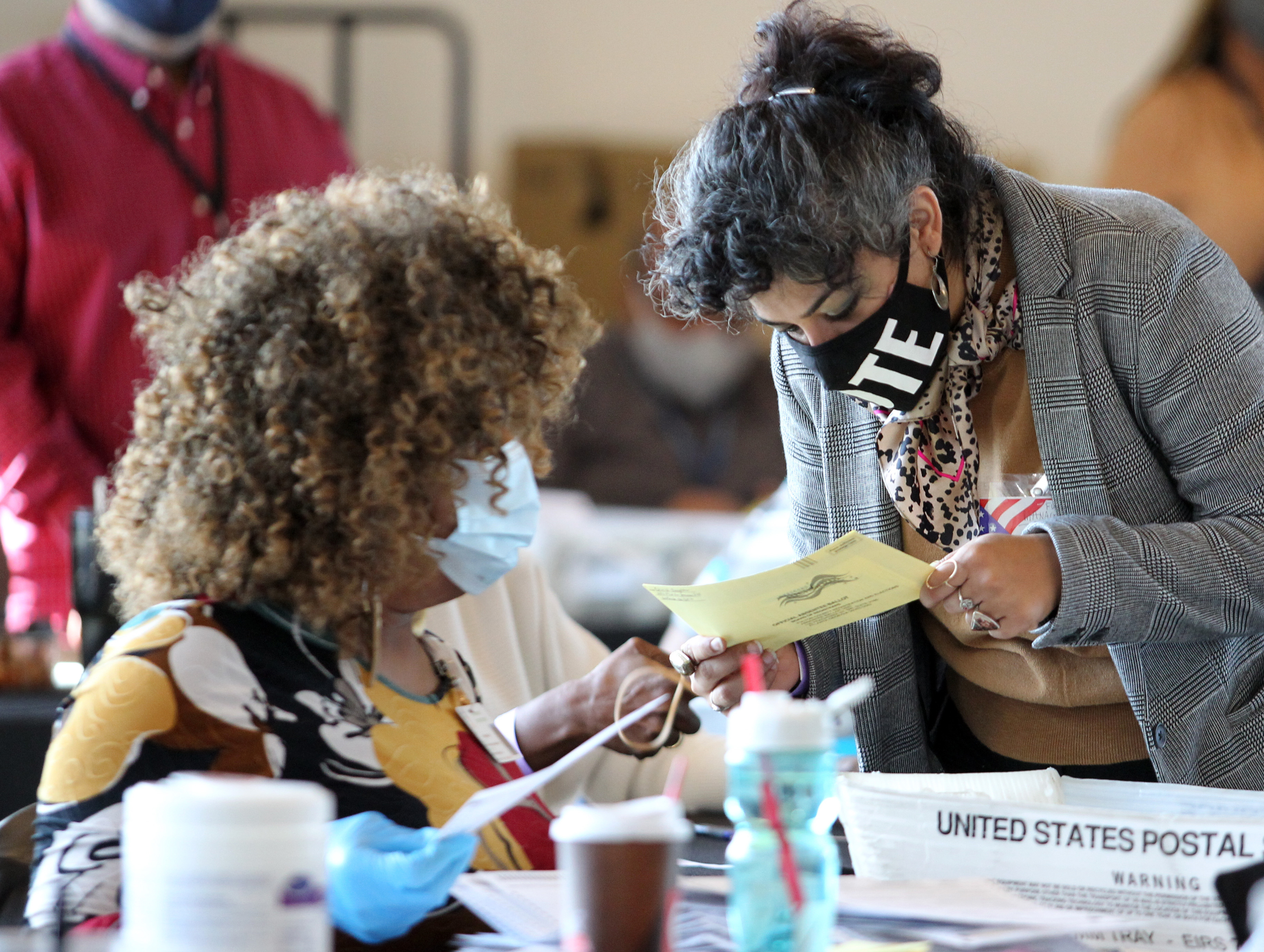 Fulton County election workers examine ballots while vote counting, at State Farm Arena in Atlanta, Georgia