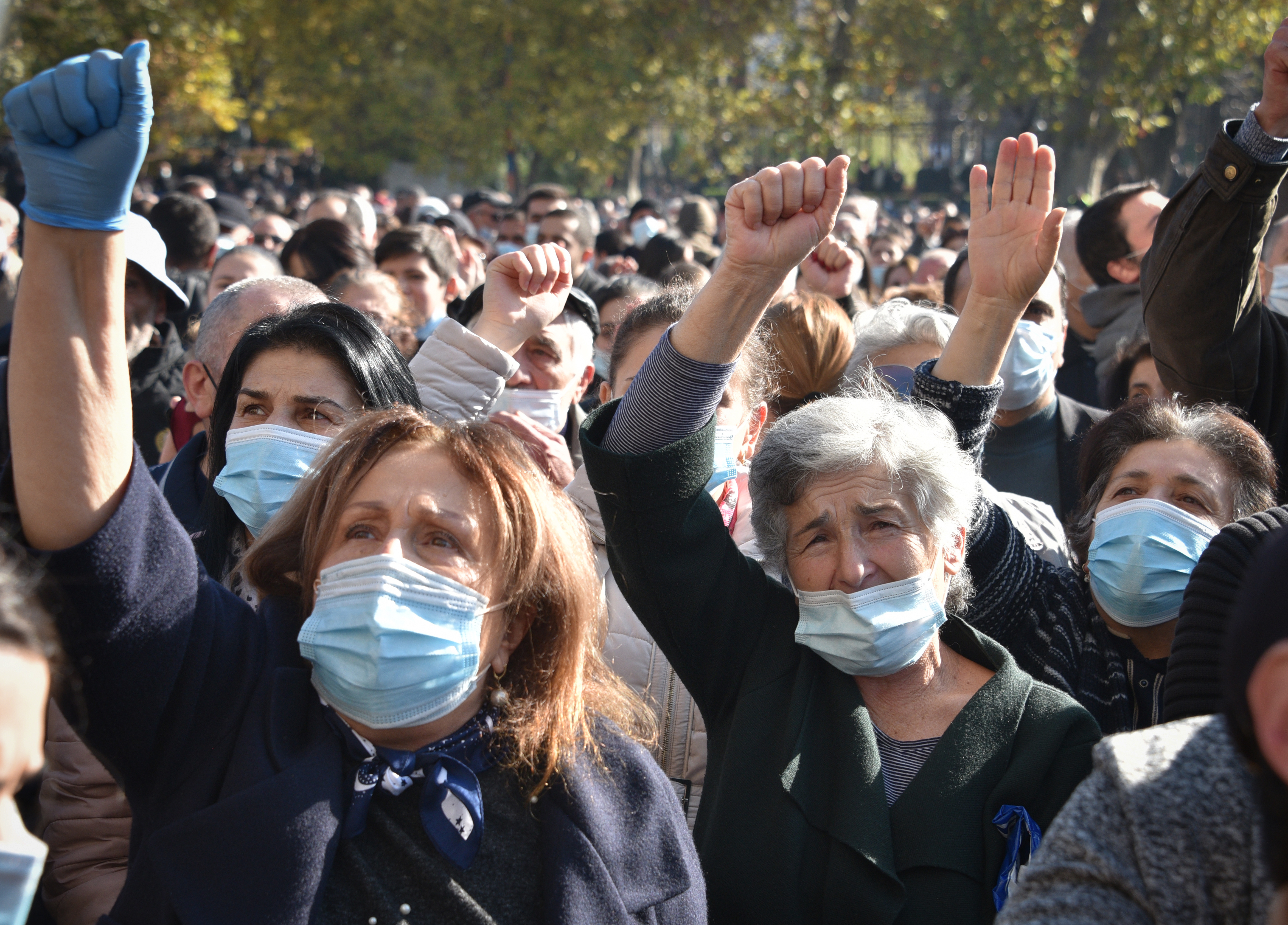Wearing protective mouth and nose masks, people protest during a rally against the country’s agreement to end fighting with Azerbaijan over the disputed Nagorno-Karabakh region outside government headquarters in Yerevan on November 11, 2020