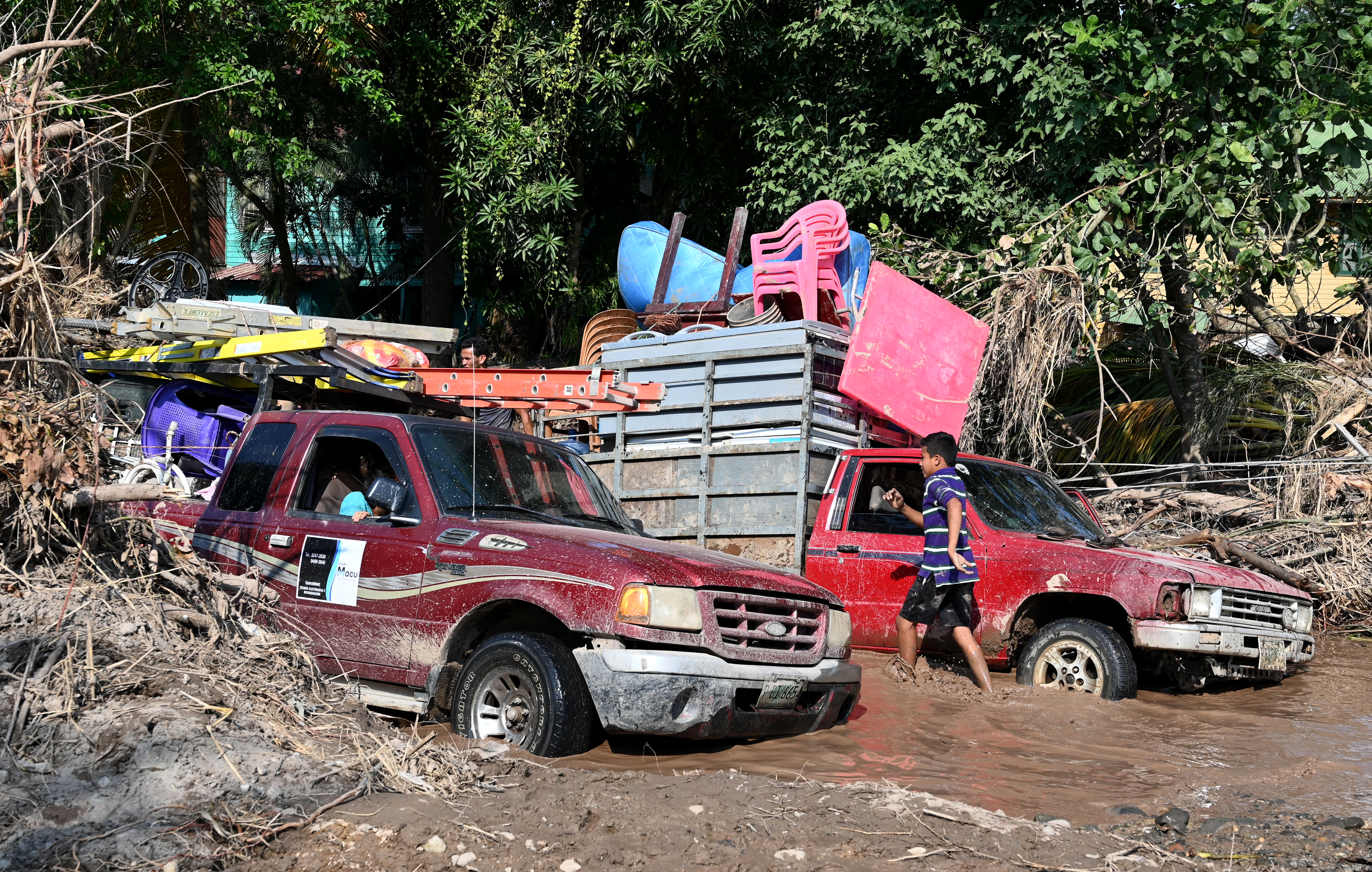 Workers from banana fields encounter a flooded road while leaving an area in El Progreso, Yoro department, Honduras, on November 14, 2020, before the arrival of Iota
