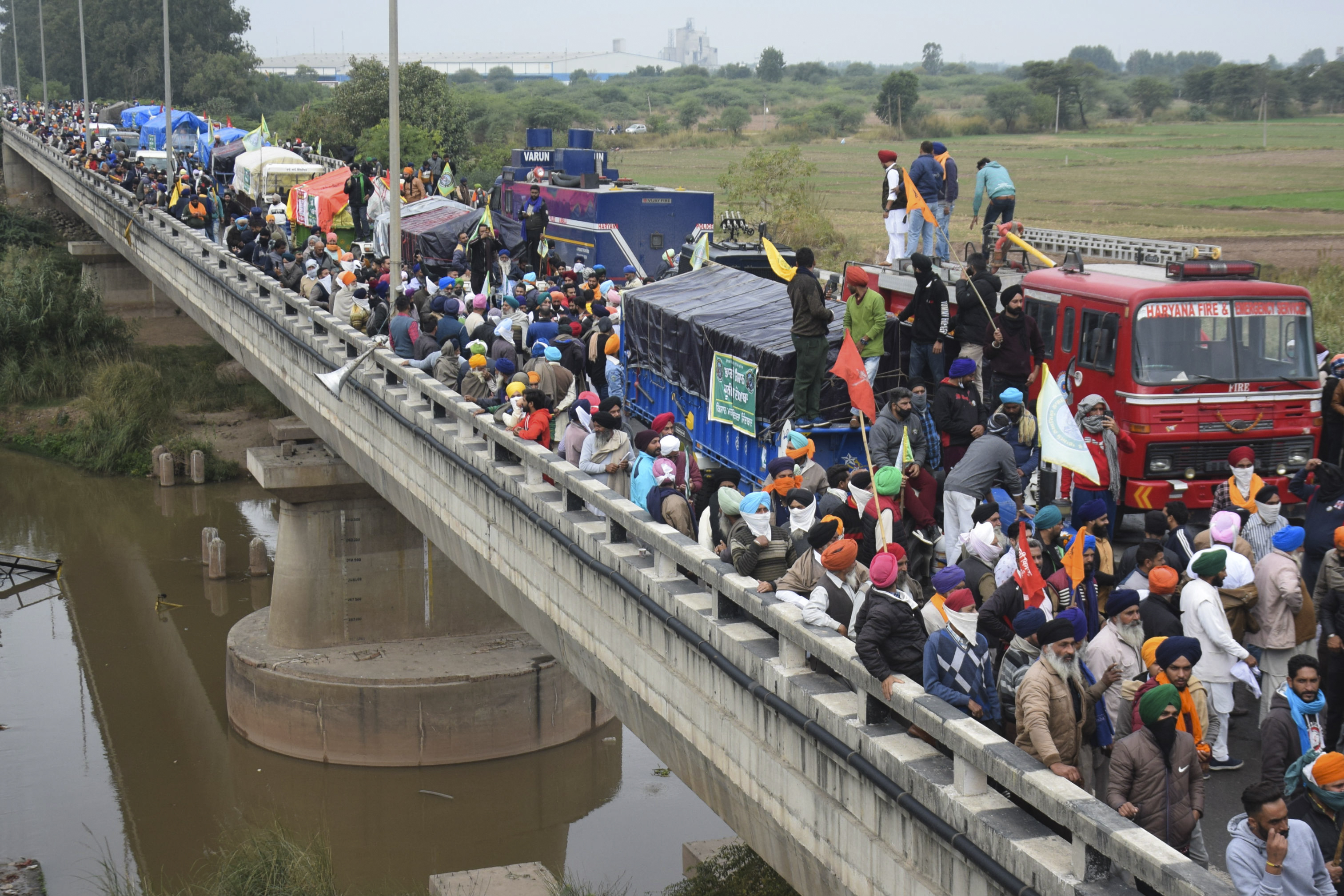 Farmers gather on a bridge as police block a road during a march to New Delhi. Police eventually allowed the marchers to continue towards the capital [AFP]