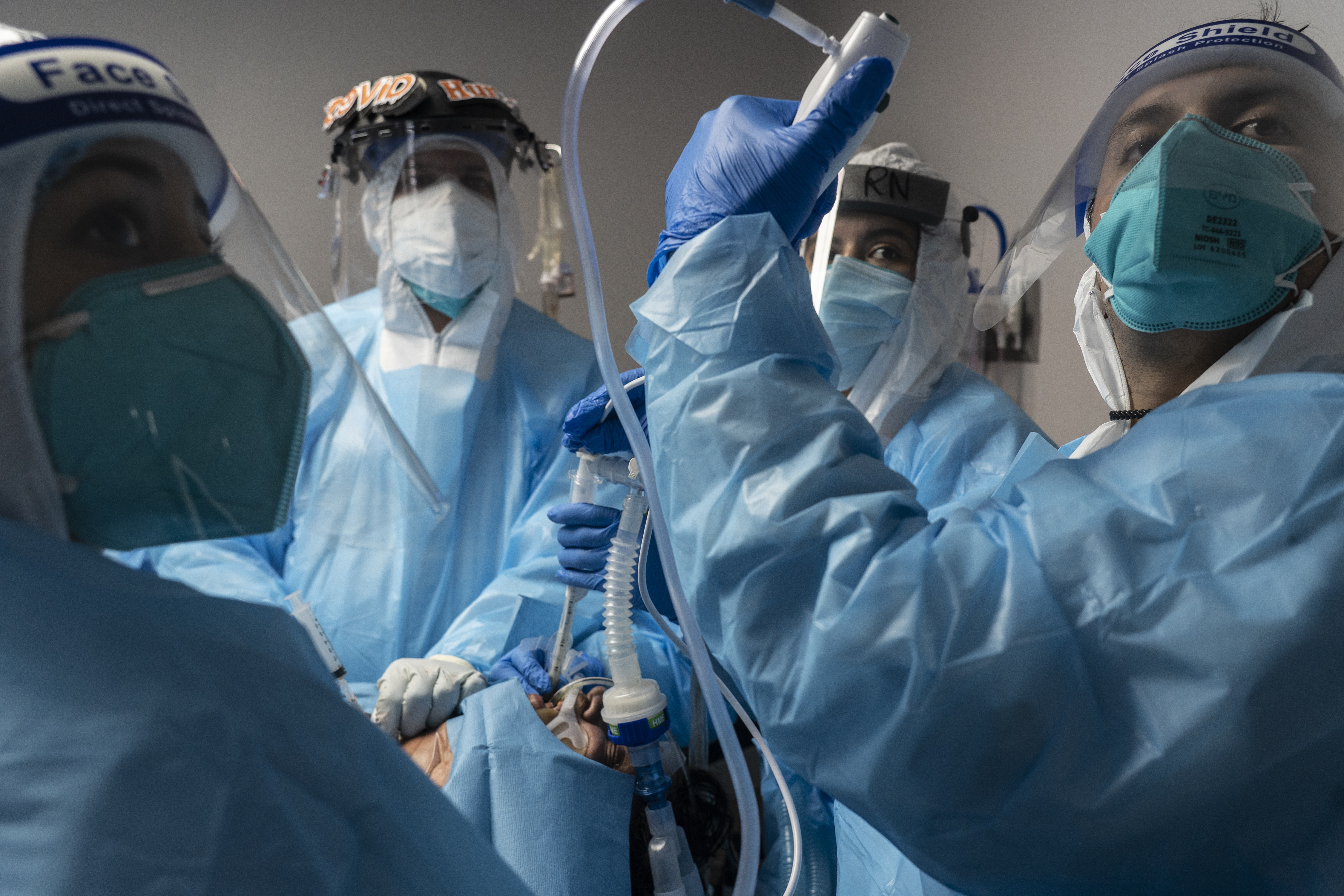 Medical staff members treat a patient suffering from the coronavirus disease (COVID-19) in the COVID-19 intensive care unit (ICU) at the United Memorial Medical Center (UMMC) on October 31, 2020 in Houston, Texas