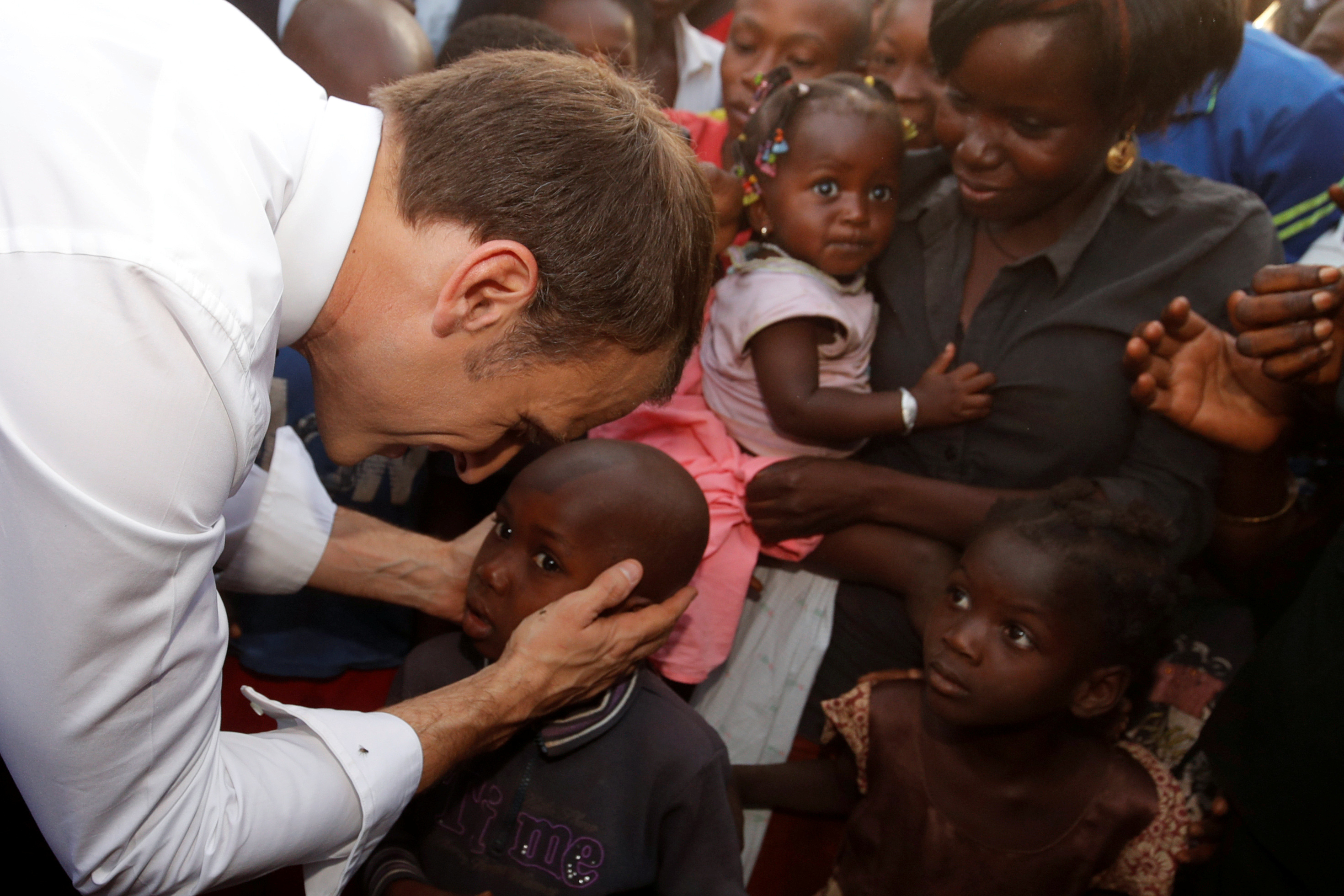 Macron greets people as he arrives to visit a school in Ouagadougou, Burkina Faso, November 28, 2017