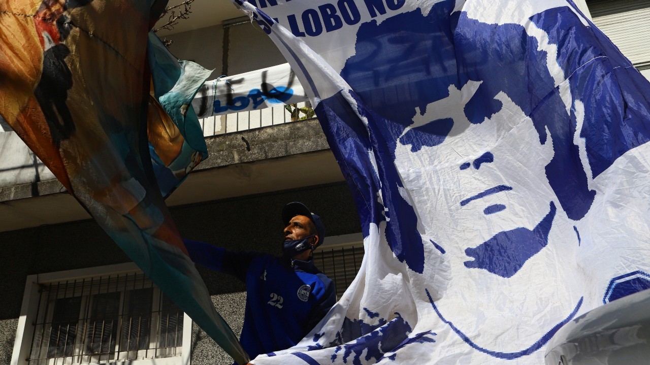 Maradona’s fans hang up a banner with his portrait outside a hospital where he was admitted