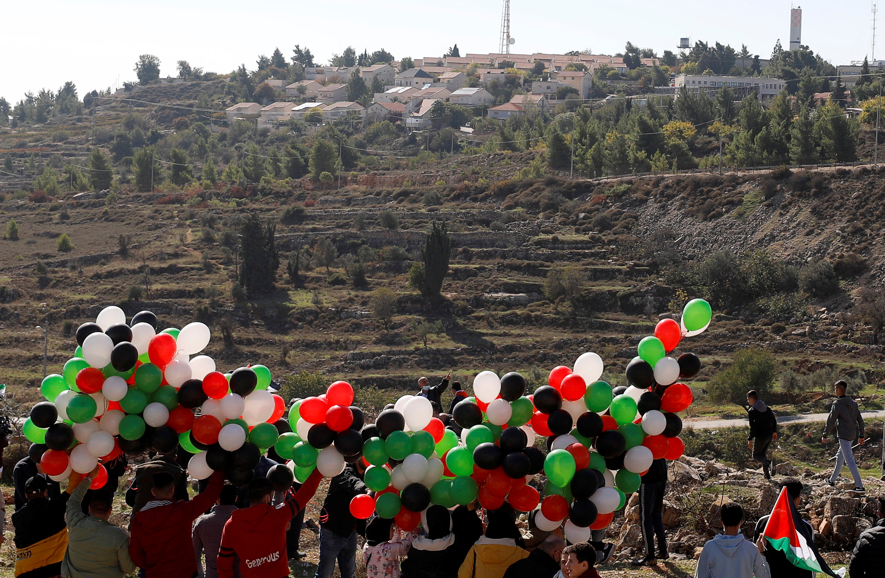 Palestinian demonstrators prepare to release balloons during a protest against US Secretary of State Mike Pompeo’s visit, near the Israeli settlement of Psagot in the Israeli-occupied West Bank