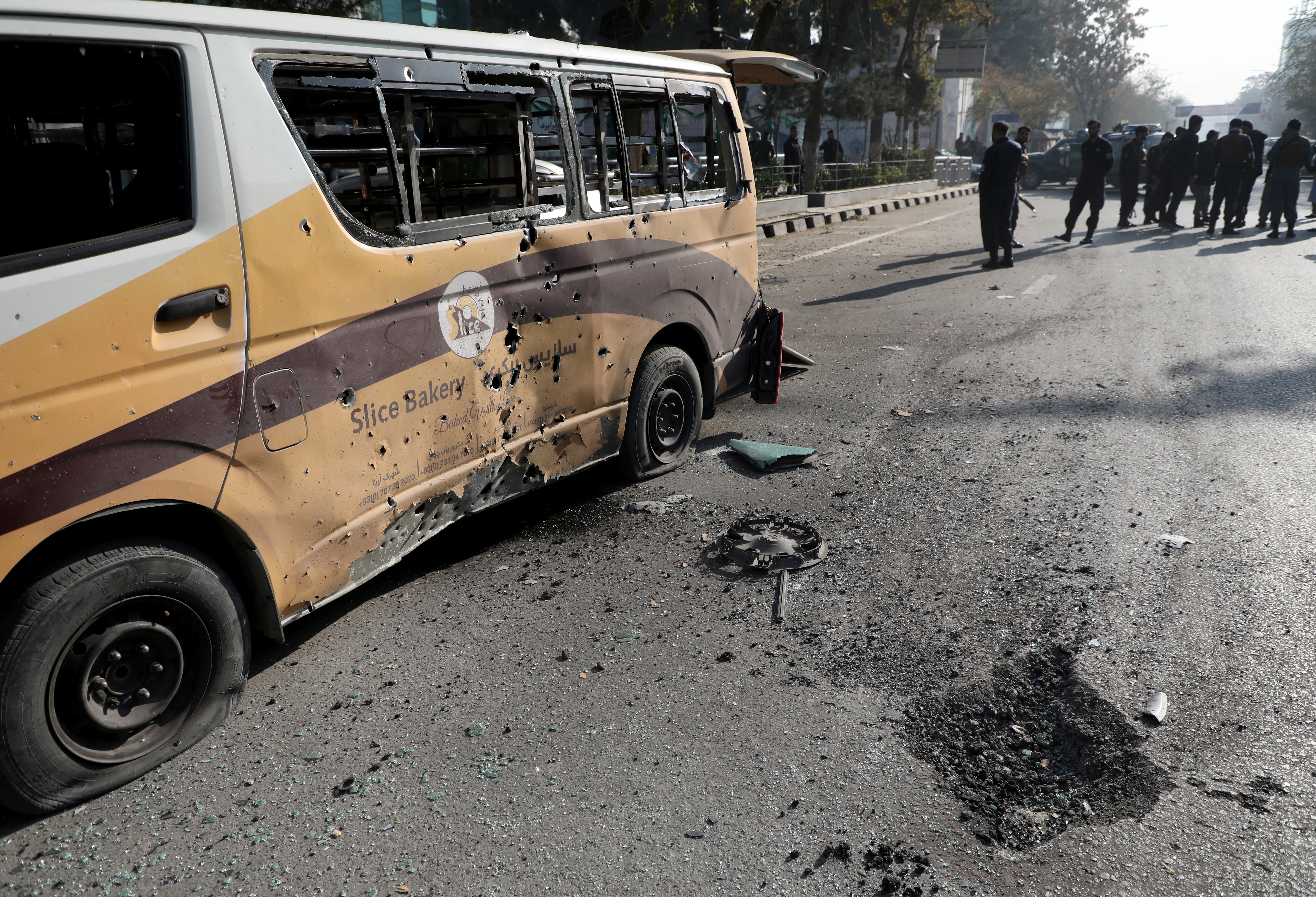 Police stand guard after rockets hit residential areas in Kabul on Saturday