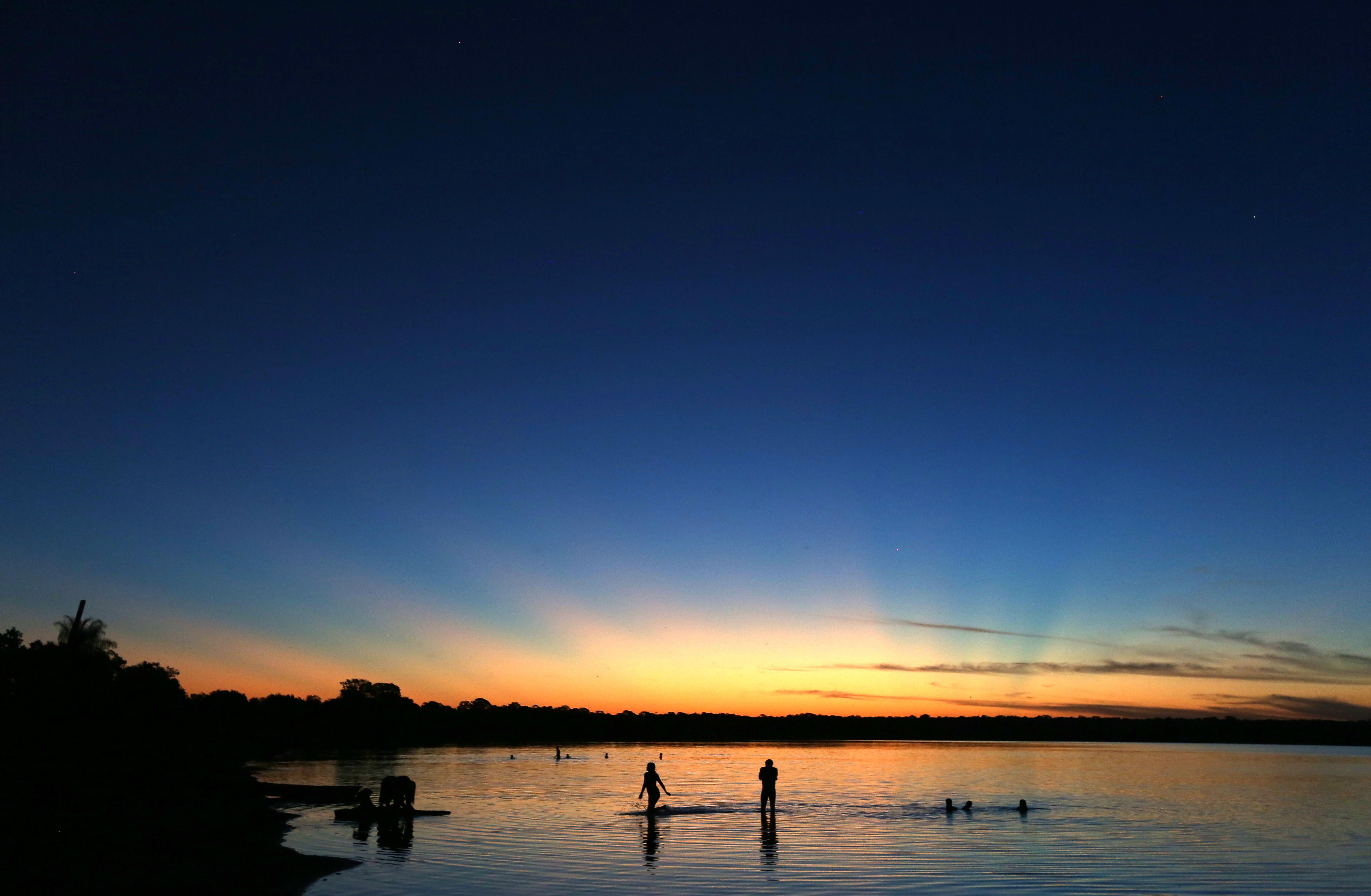 Indigenous people bathe in the lake in Xingu