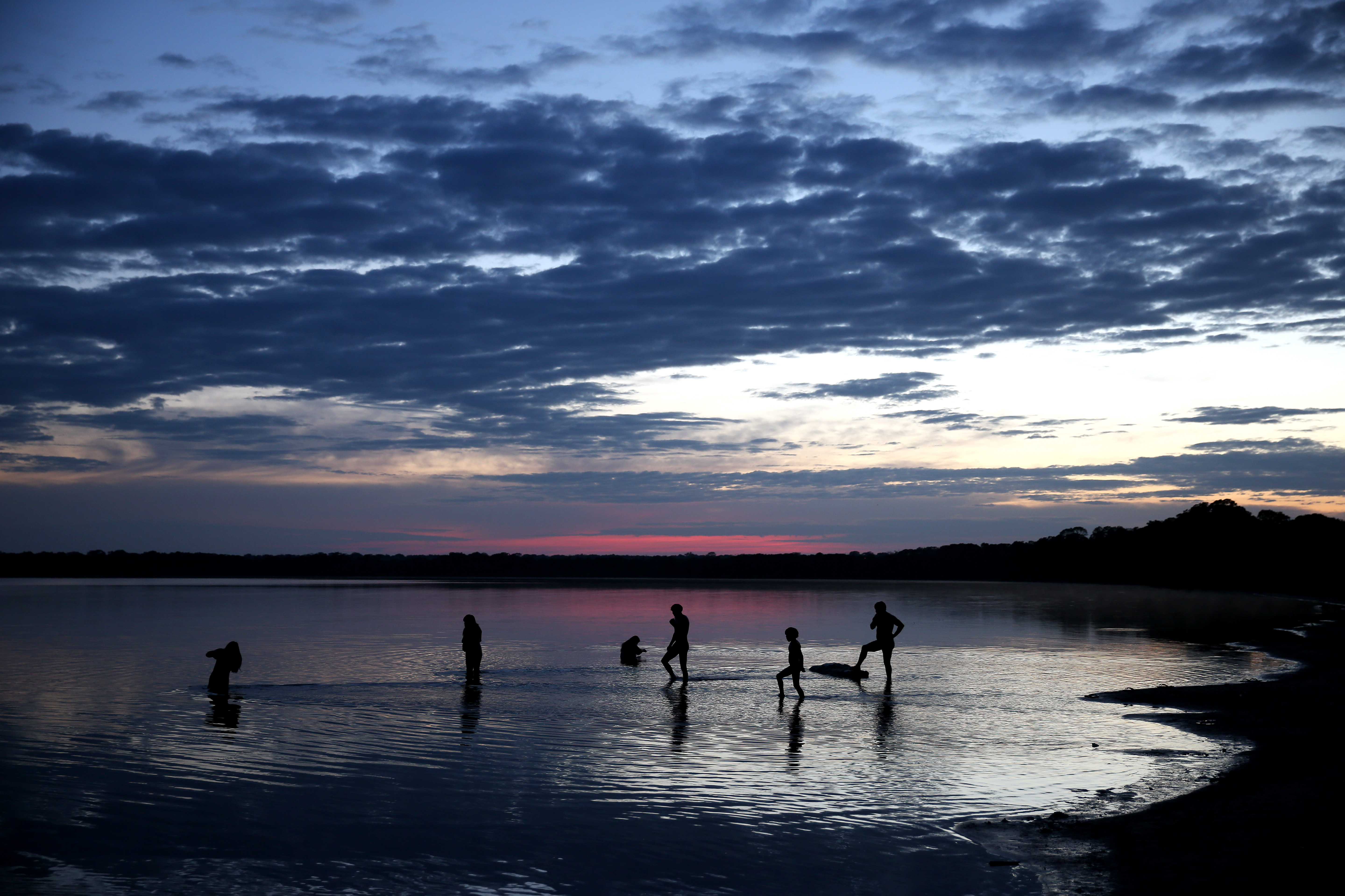 Indigenous people bathe in the lake in Xingu