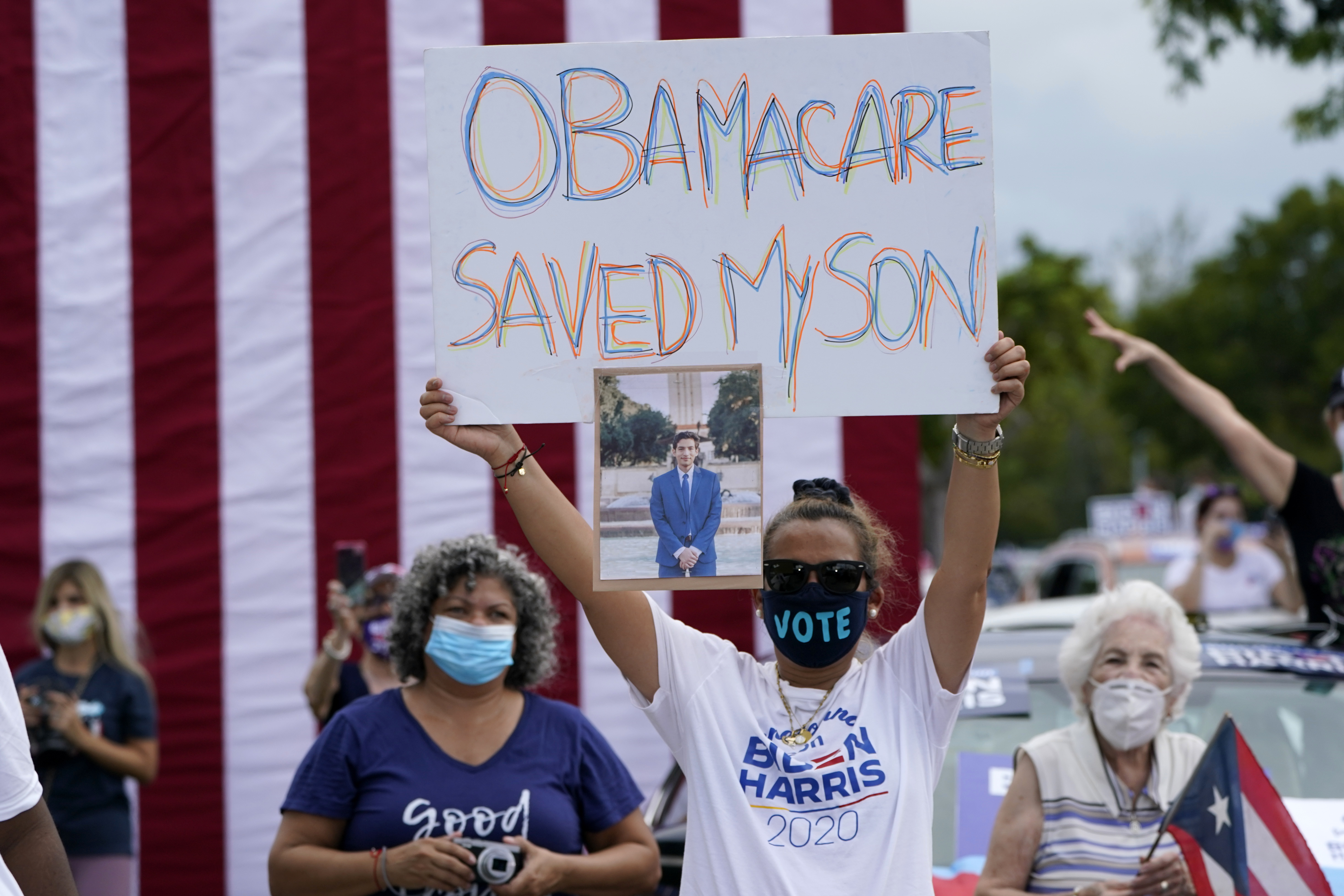 A woman in Florida holds a sign in support of Obamacare in October 2020, ahead of the US election [AP]