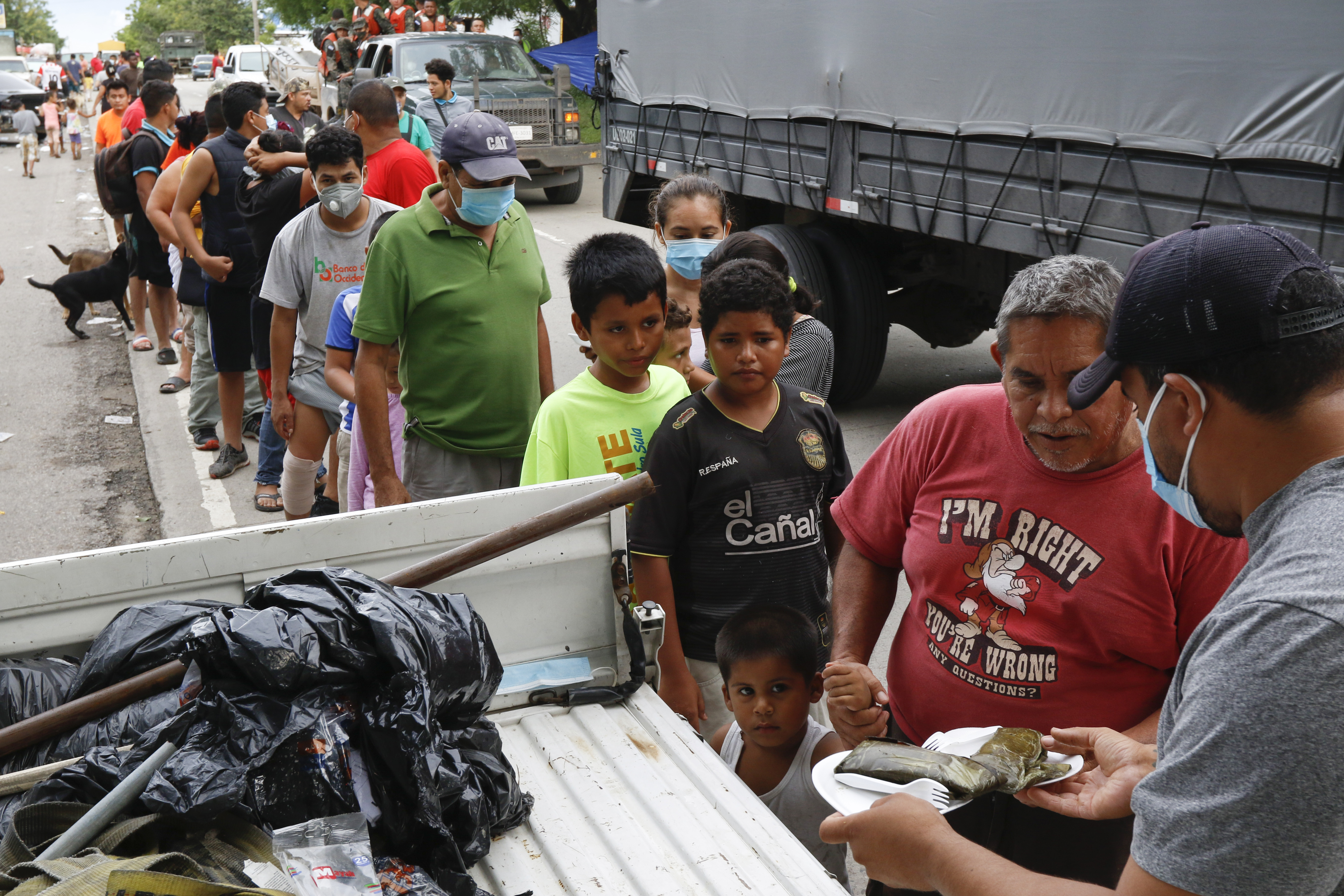 Residents affected by Hurricane Eta stand in a line to receive donated food in Planeta, Honduras