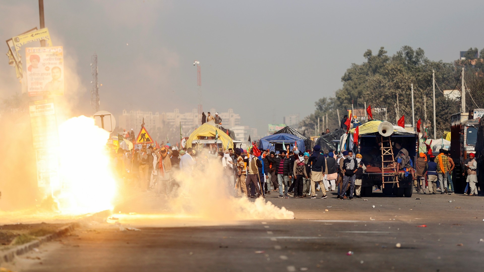 Flames emerge from tear gas released by the police to stop farmers from entering New Delhi