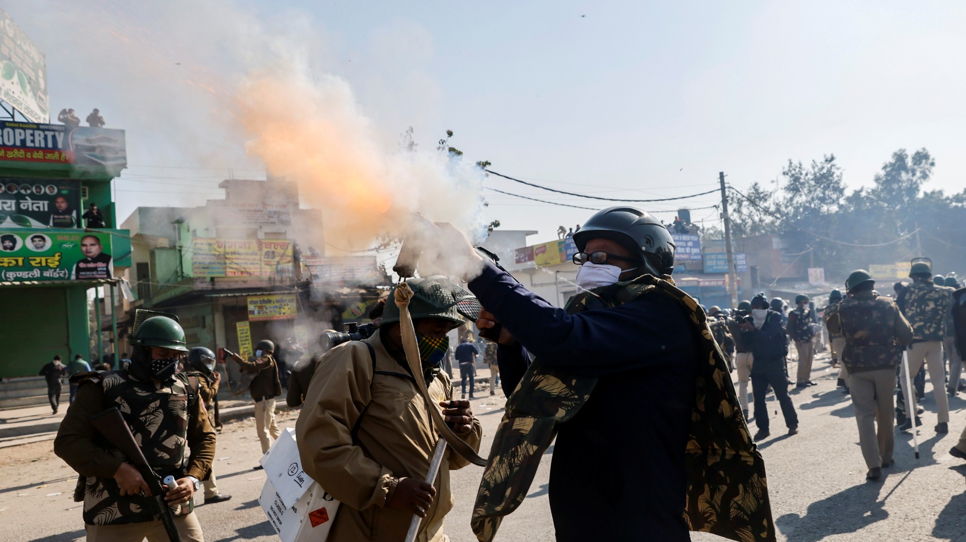 A police officer fires tear gas to stop farmers from entering the national capital