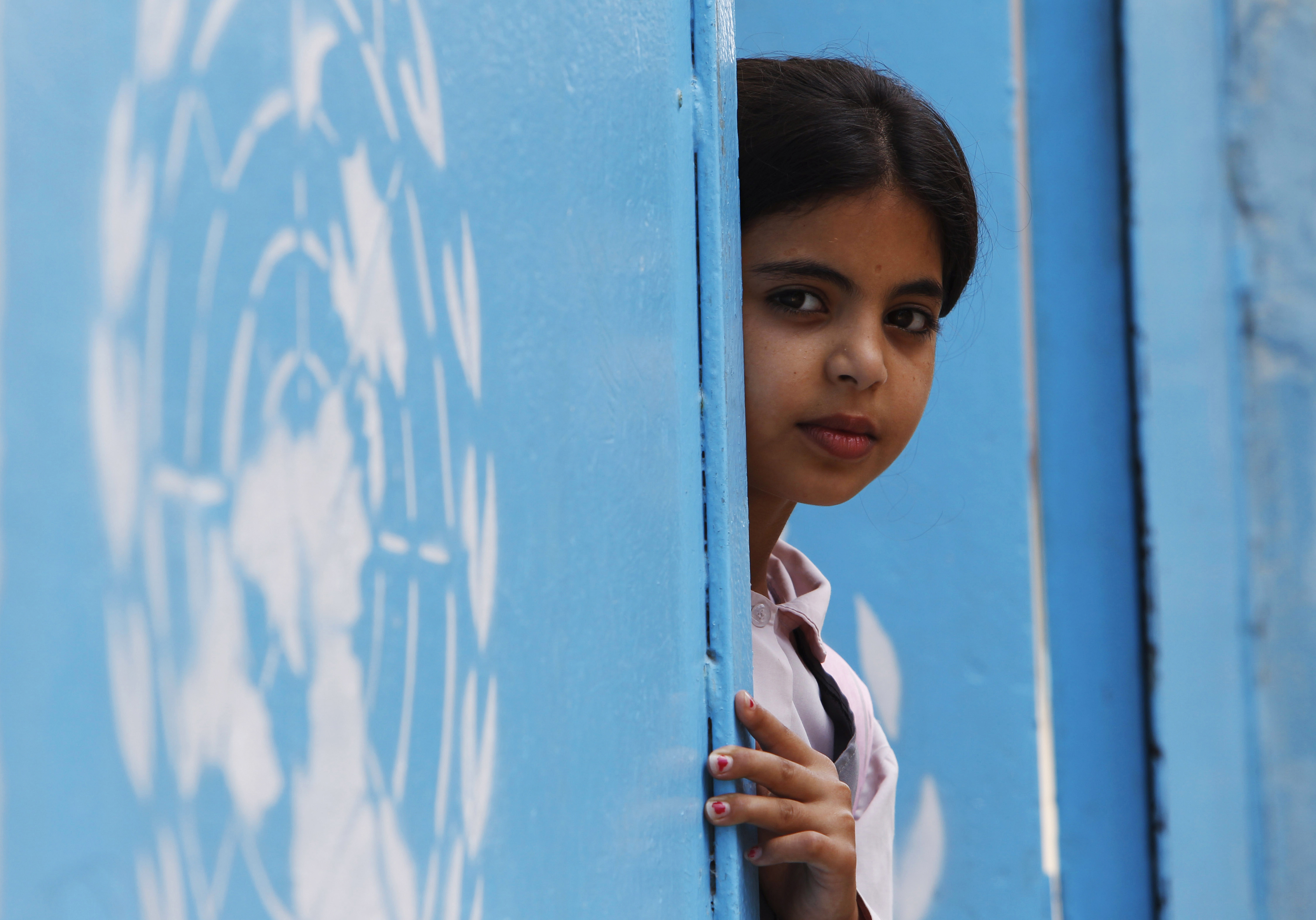 A Palestinian refugee student peers from behind a United Nations Relief and Works Agency (UNRWA) school door at Ain al-Hilweh refugee camp in southern Lebanon