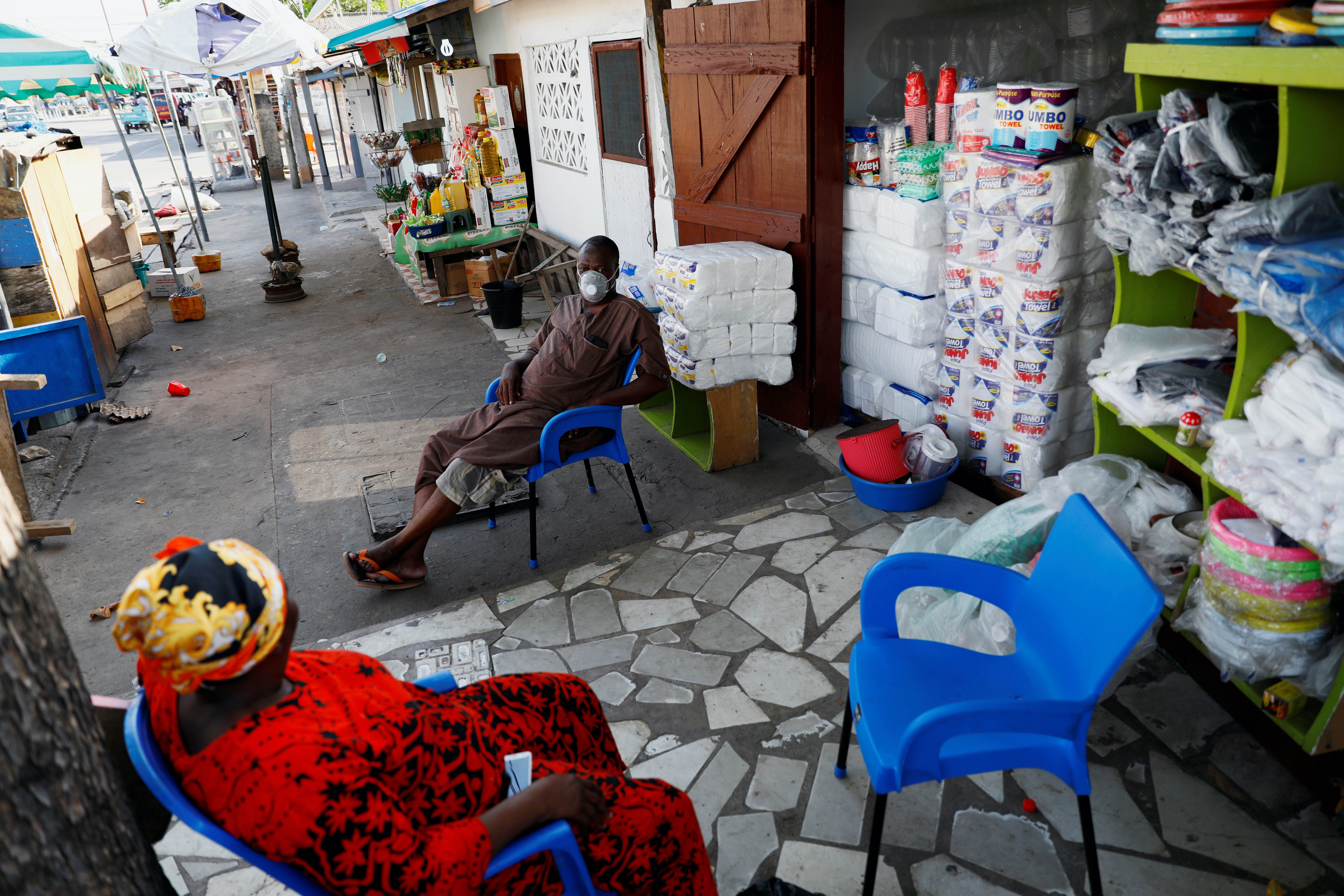 Traders sit in front of their shop as Ghana lifts partial lockdown amid the spread of the coronavirus in Accra