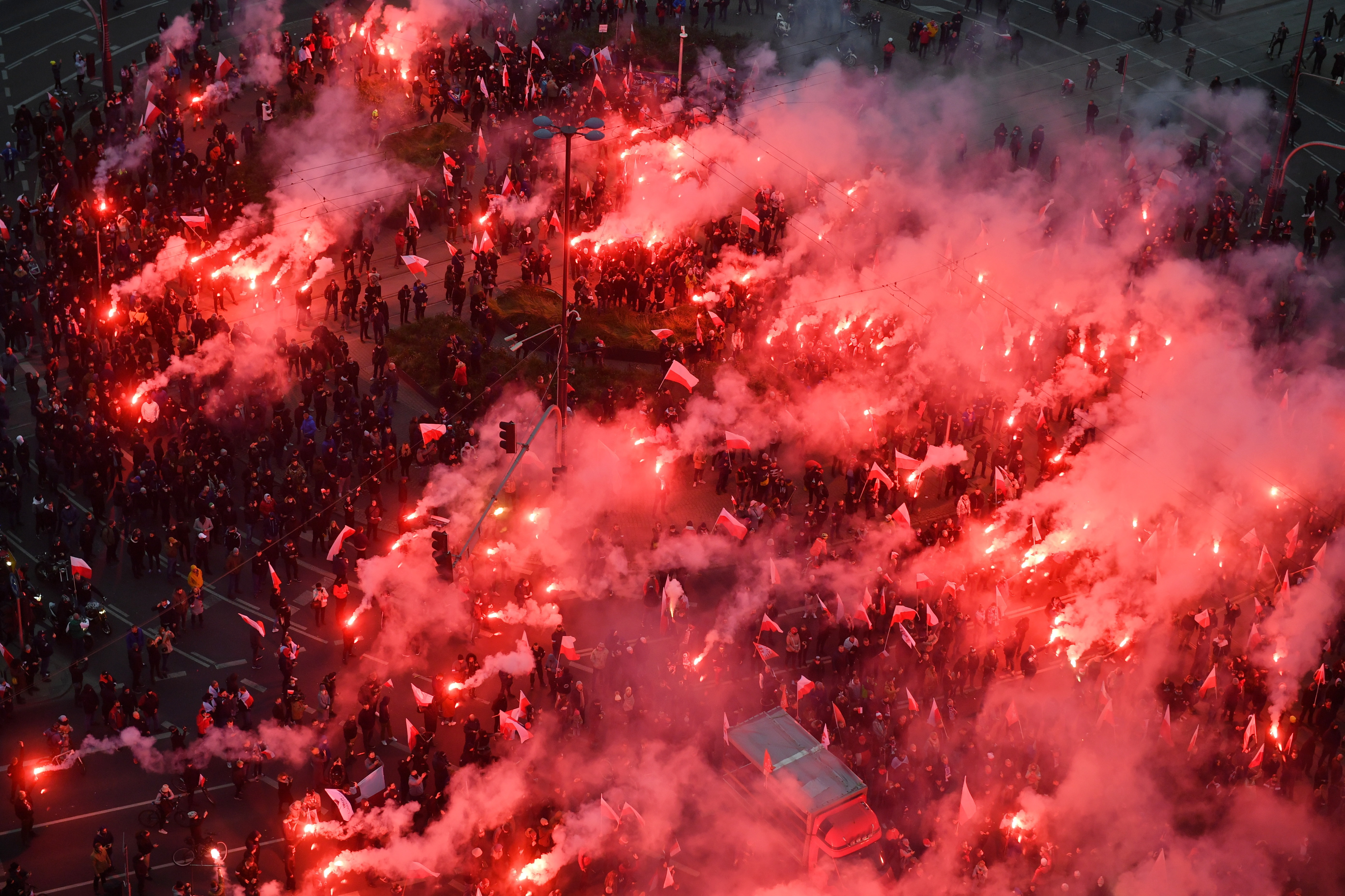 Participants at the march burn red flares at the Dmowski roundabout in Warsaw