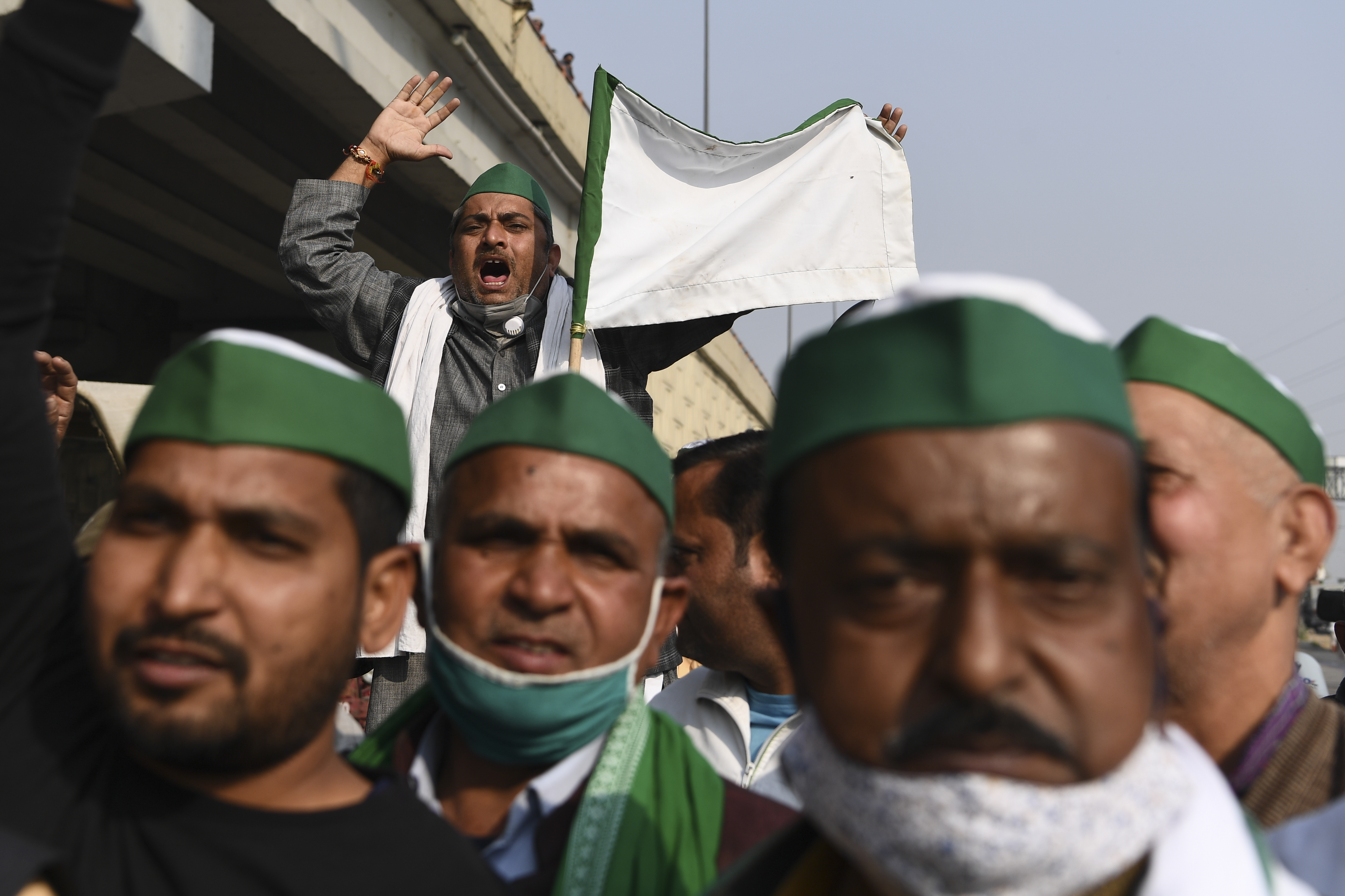 Farmers shout slogans near a police roadblock stopping farmers from marching to New Delhi to protest against the central government’s recent agricultural reforms at the Delhi-Uttar Pradesh border in Ghazipur, India