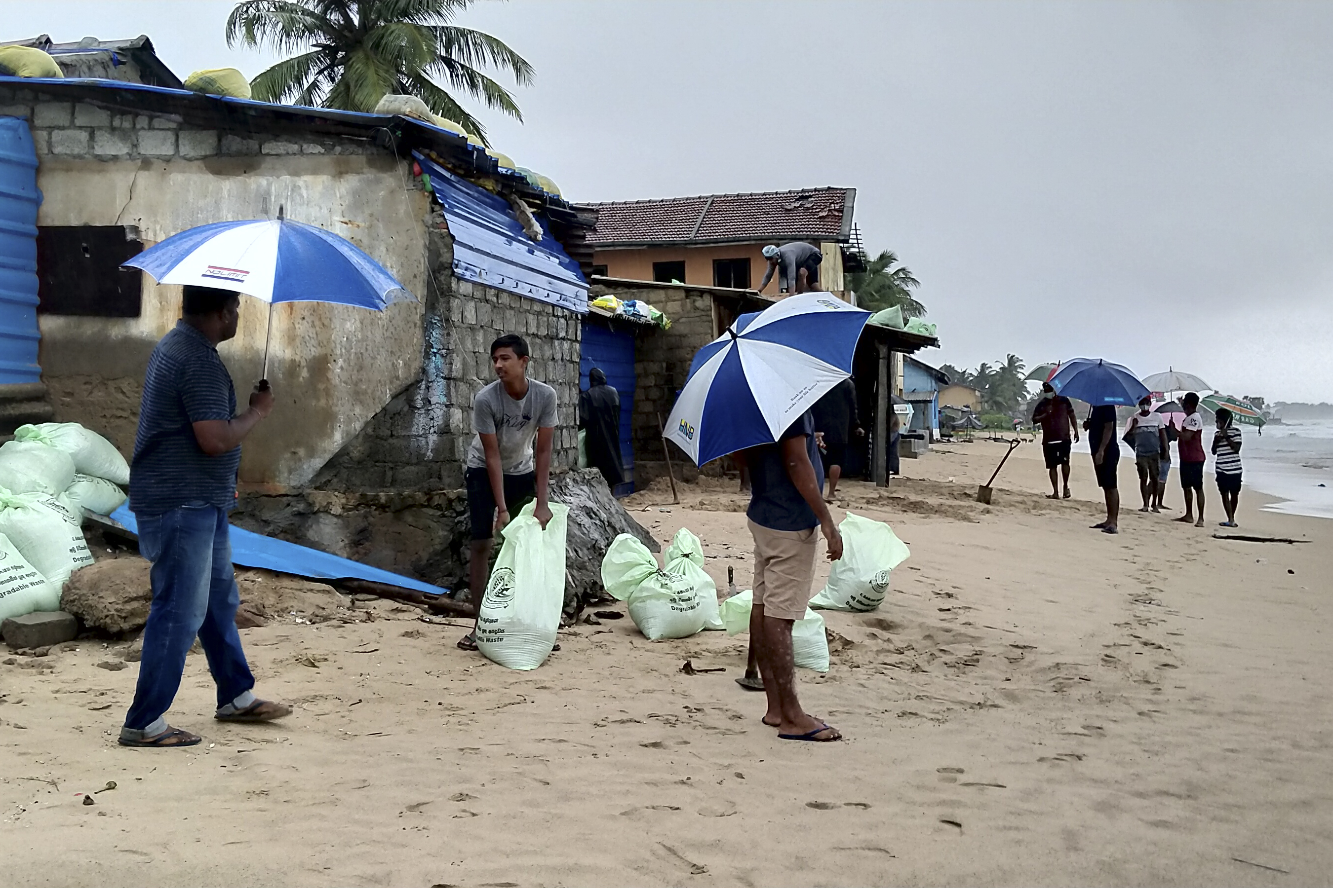Residents prepare sand bags to protect their homes ahead of cyclone Burevi landfall in Sri Lanka’s north-eastern coast in Trincomalee [AFP]
