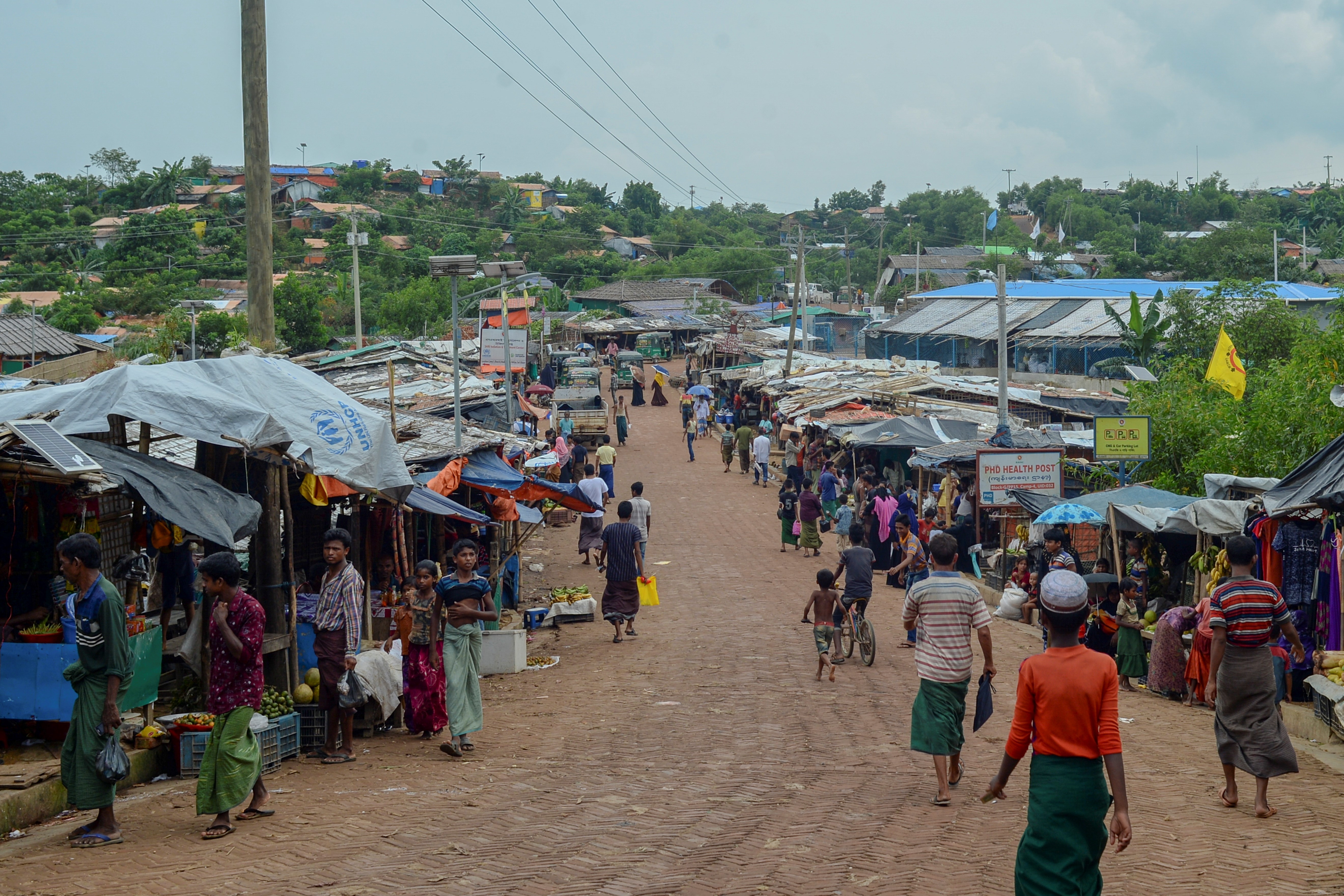 Rohingya make their way along a market area at Kutupalong refugee camp in Ukhia, Bangladesh [File: Munir Uz Zaman/AFP]