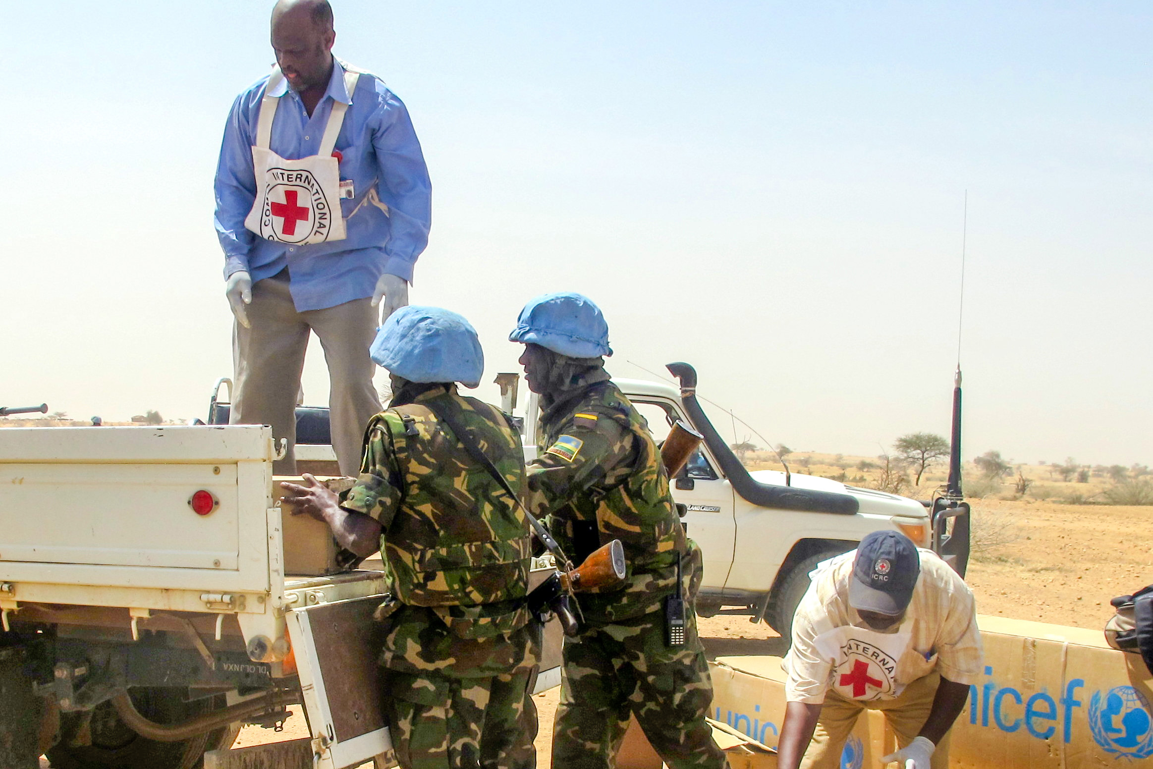 A handout picture released by the United Nations-African Union Mission in Darfur (UNAMID) shows its peacekeepers and Red Cross personnel unloading boxes of medical and other supplies to the victims of El Sereif as part of its ongoing efforts to address the needs of civilians affected in the North Darfur tribal clashes on February 24, 2013 in el-Fasher, in North Darfur [AFP]