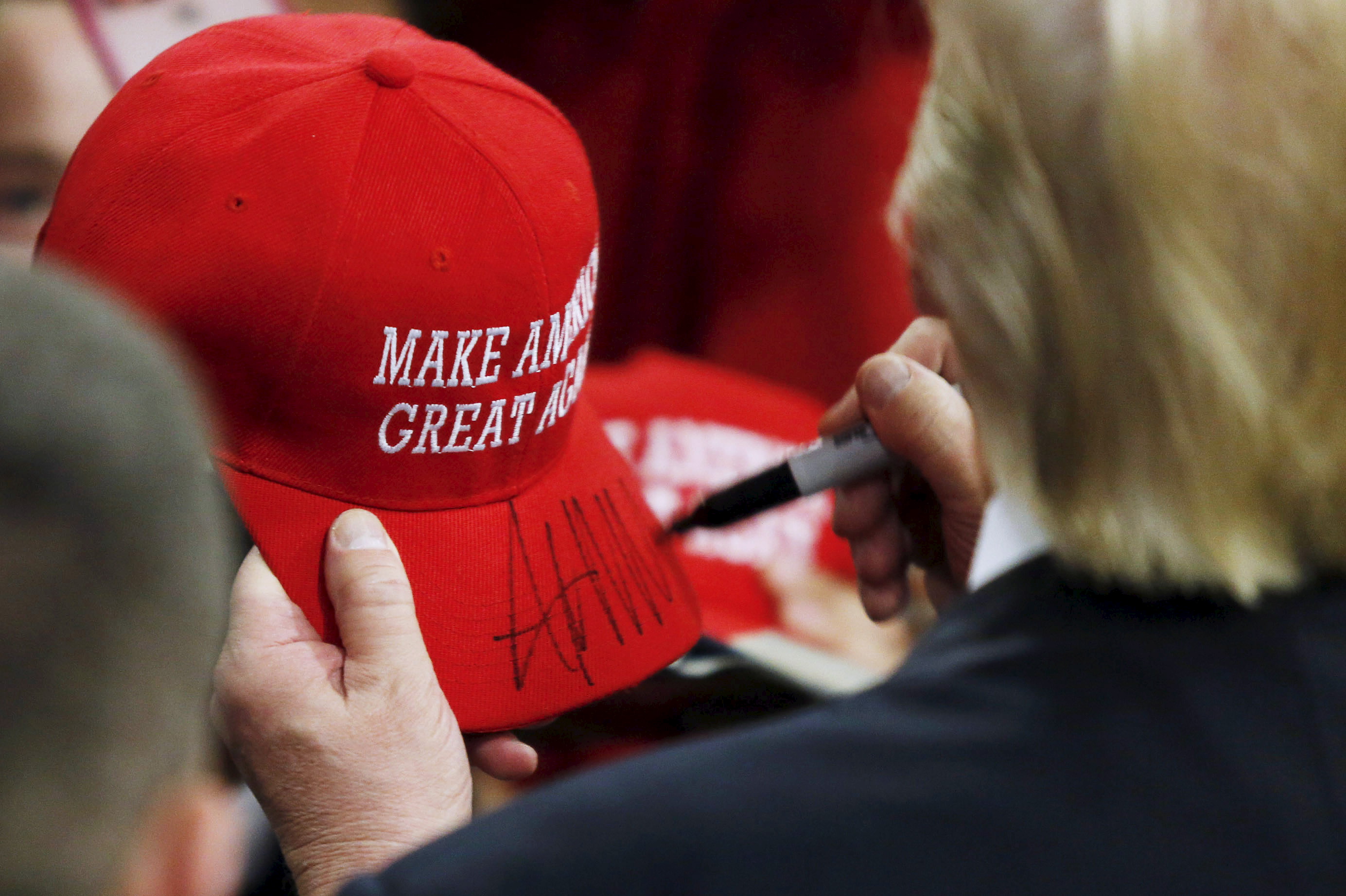 Trump signs a hat at a campaign rally in West Chester, Pennsylvania, April 25, 2016