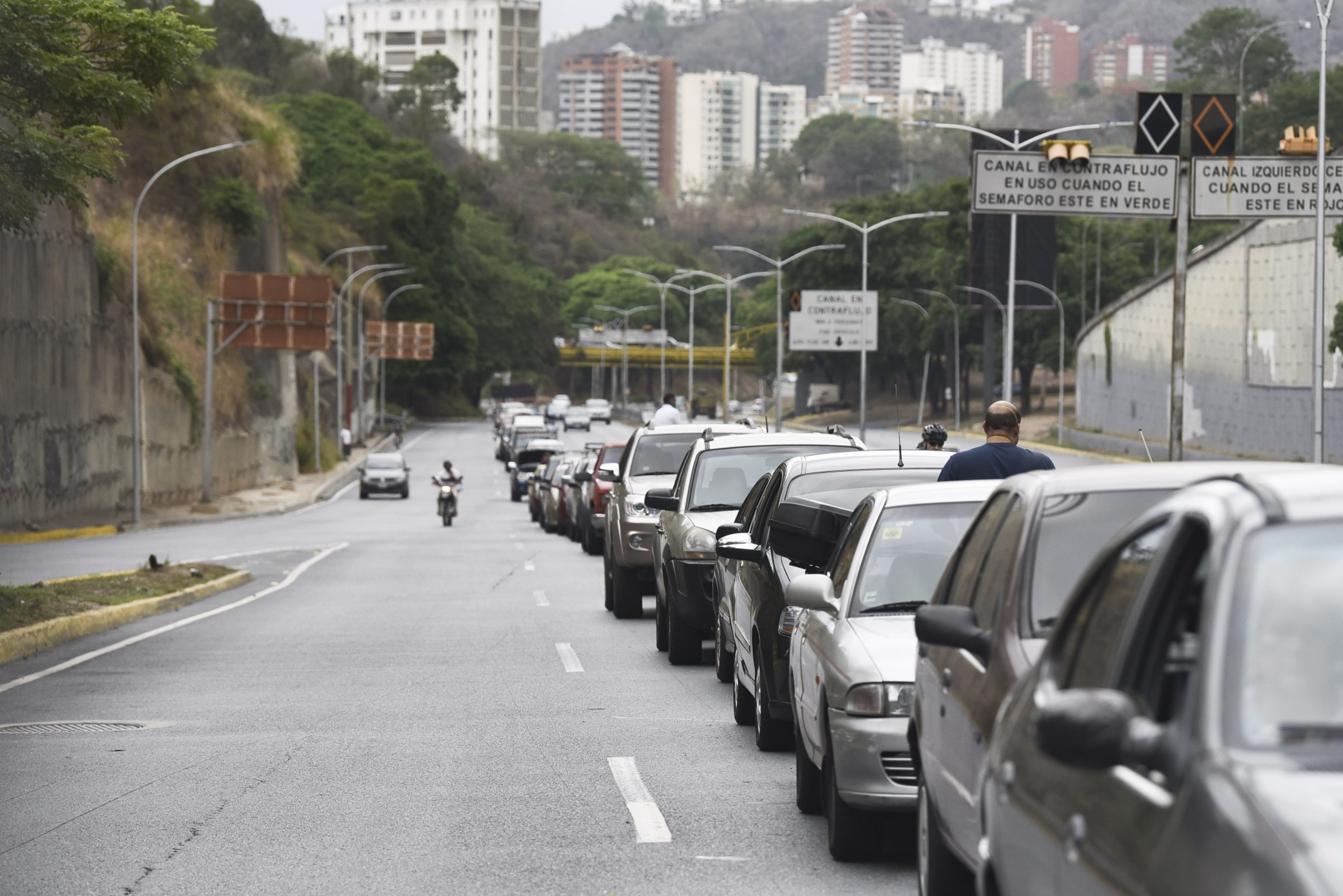A line of cars waits to refuel outside a PDVSA gas station in Caracas [Bloomberg]