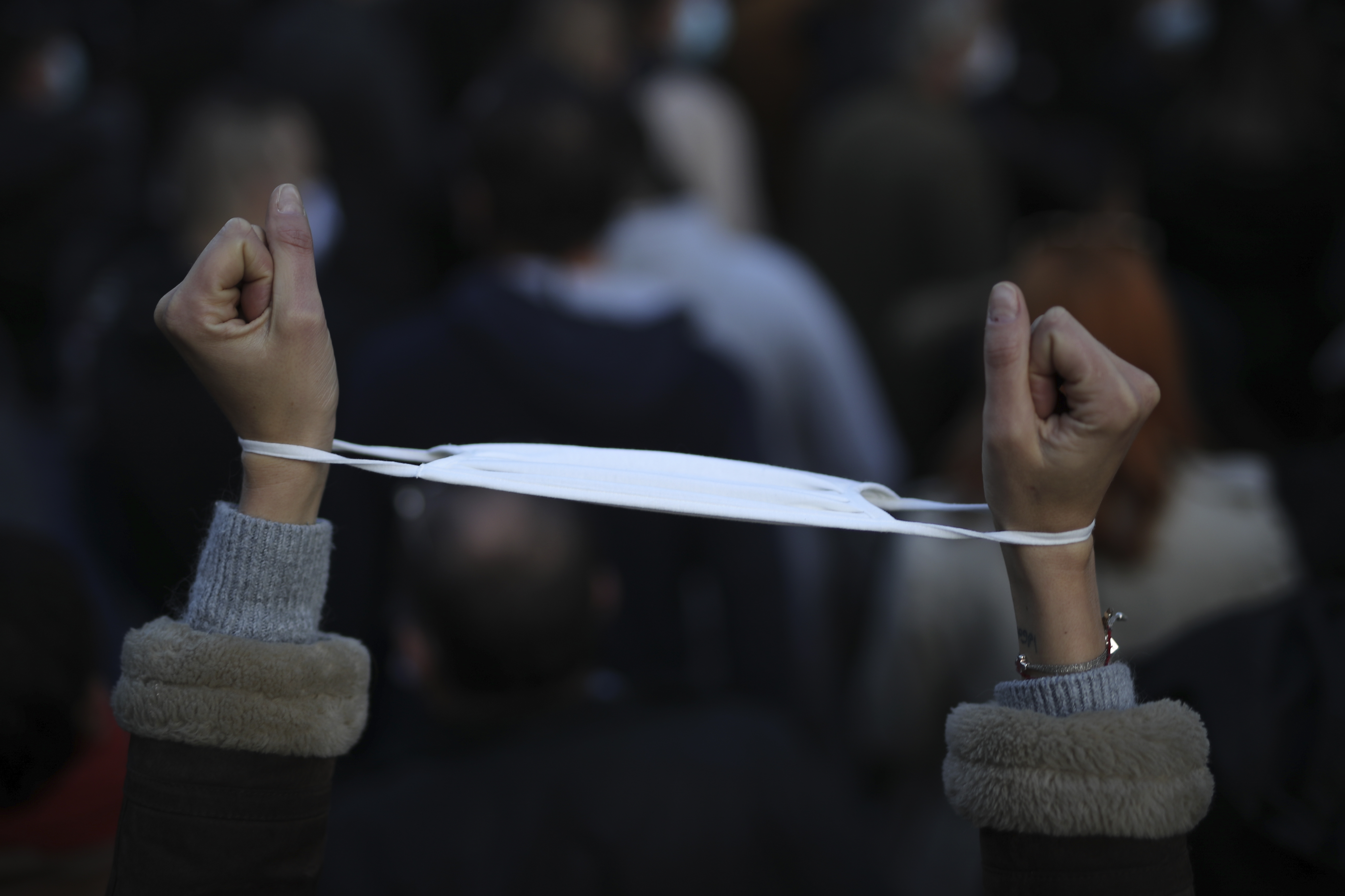 A demonstrator has her mask around her wrists as restaurants, bars and night clubs owners protest in Marseille, France in November