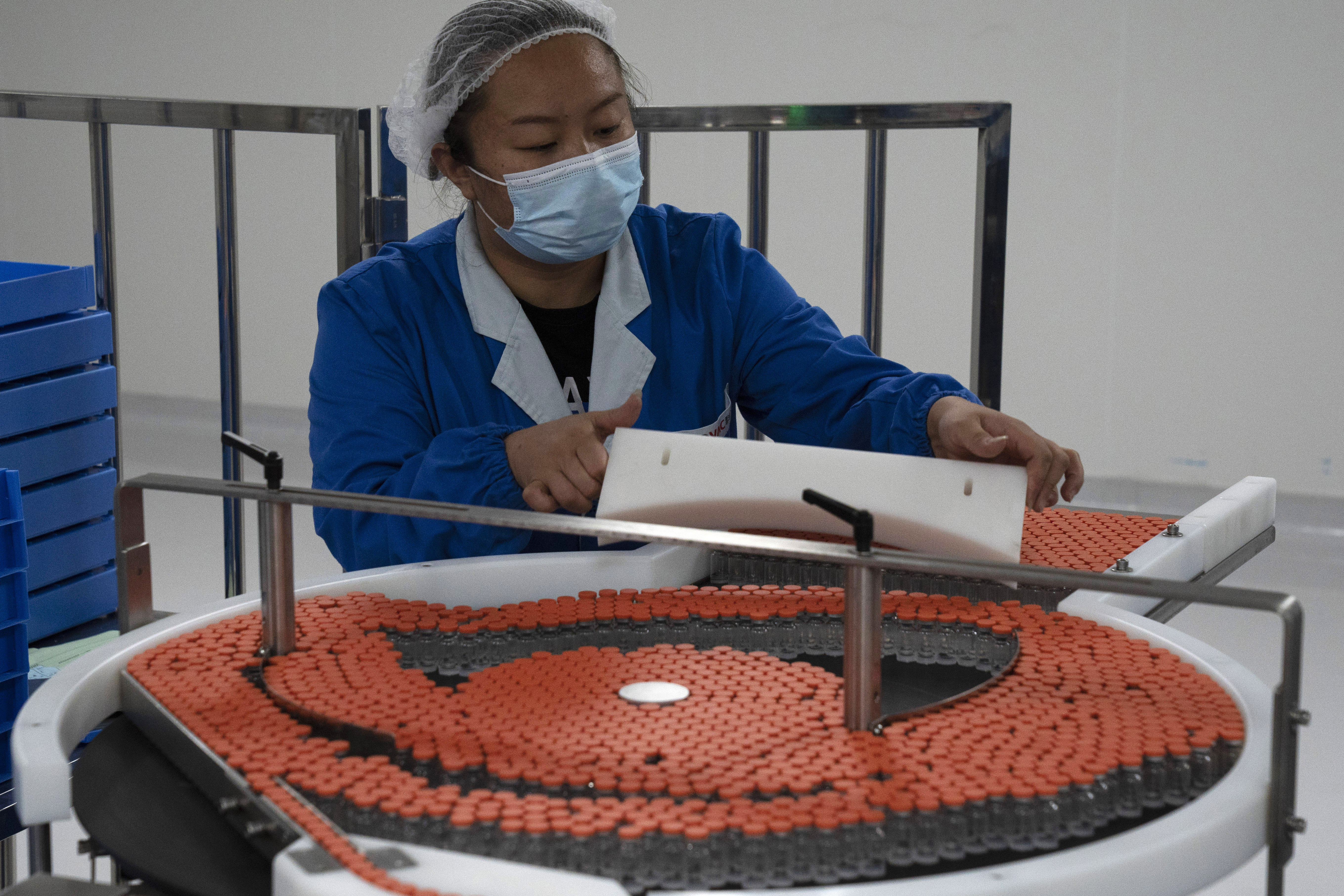 A worker loads vials to be used in the production line for a vaccine for COVID-19 at Chinese company Sinovac at its factory in Beijing