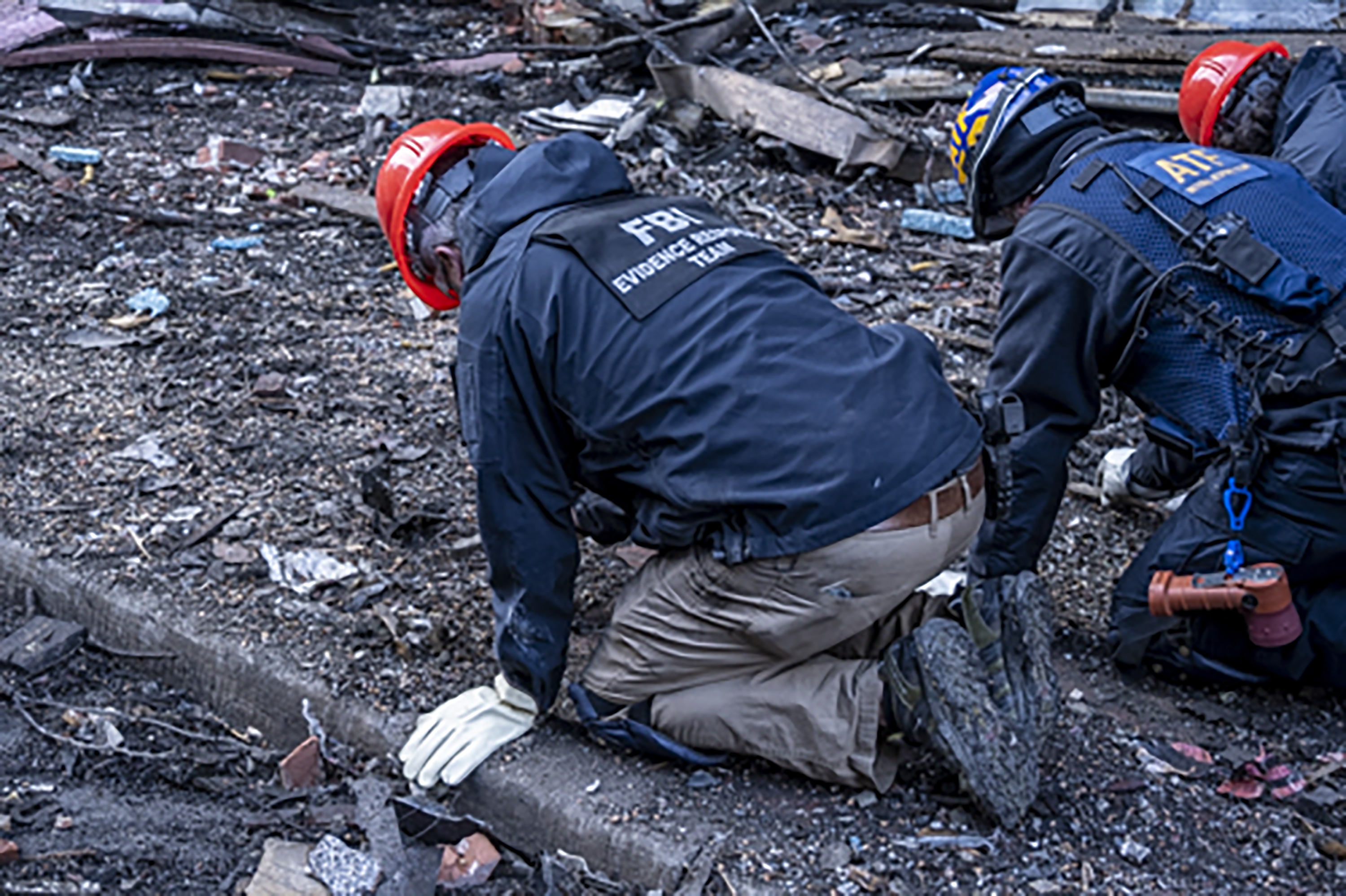 In this photo provided by the FBI and Bureau of Alcohol, Tobacco, Firearms and Explosives, FBI and ATF Evidence Response Teams search for evidence, at the site of the Christmas Day blast in Nashville, Tennessee