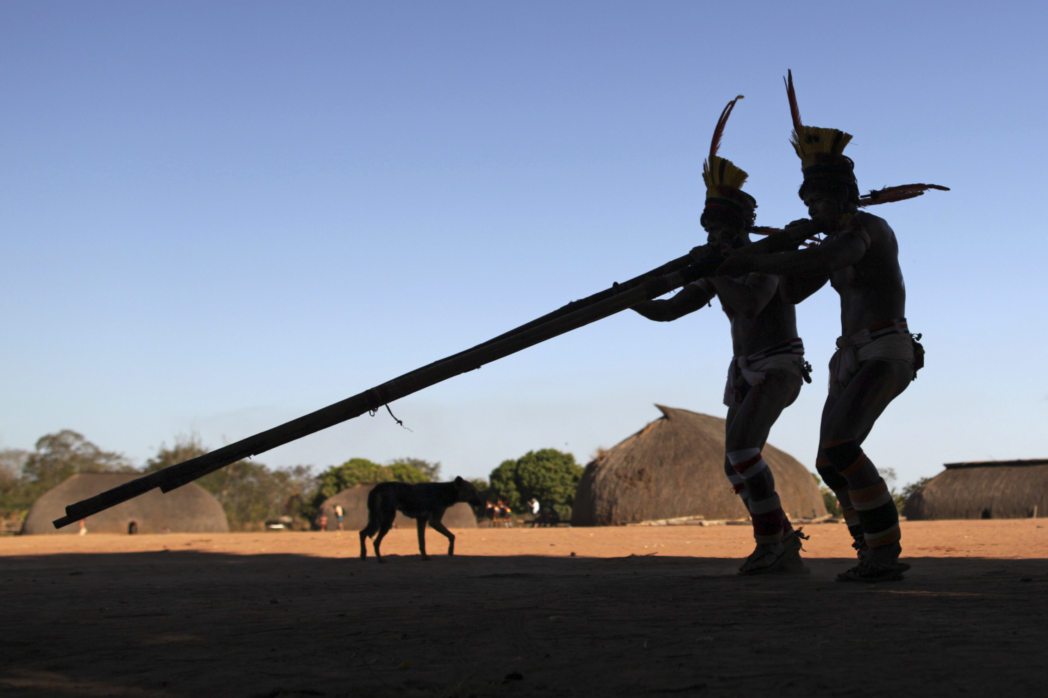 Yawalapiti men play bamboo flutes during ‘quarup’, a ritual to honour in death a person of great importance to them, in Xingu