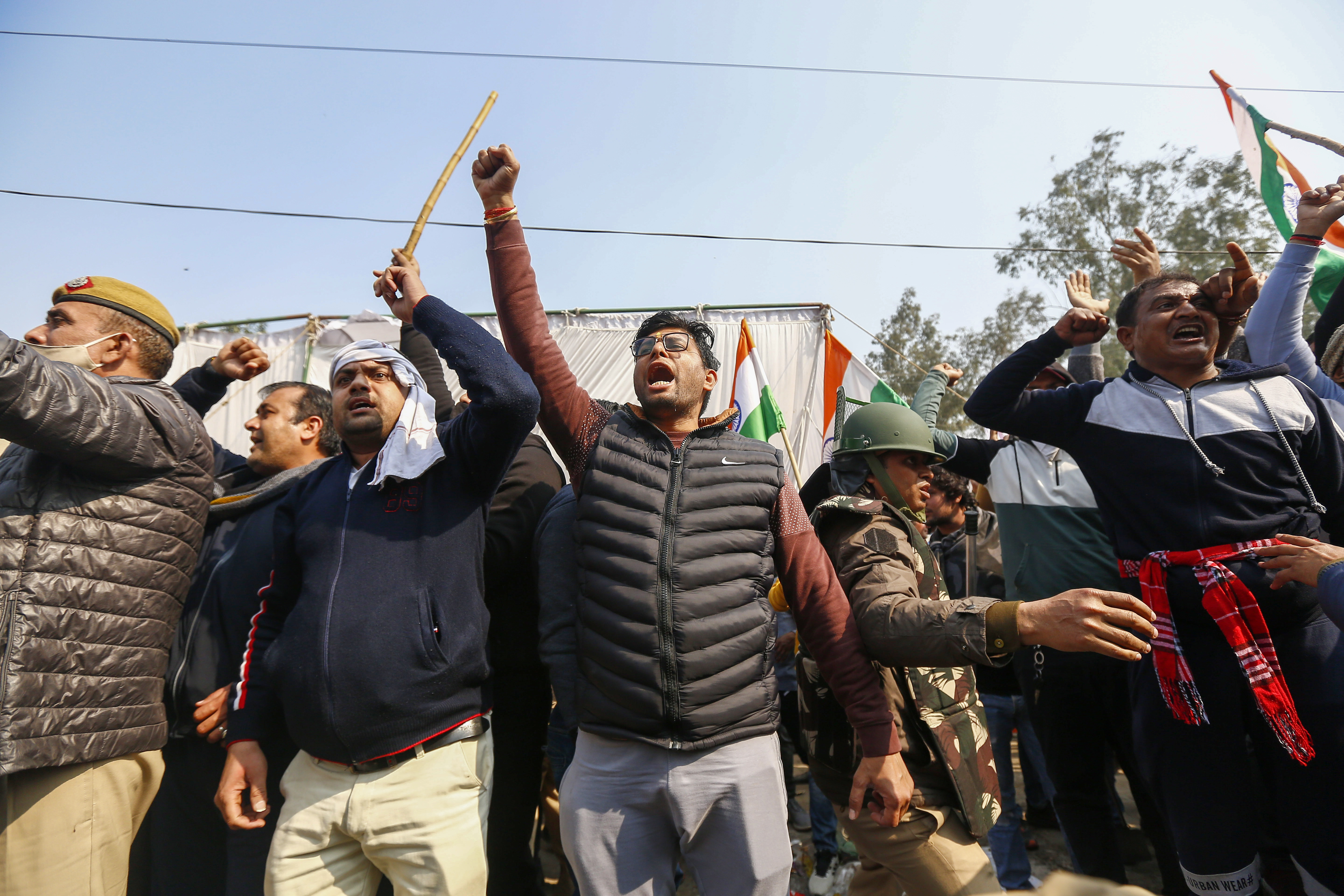 Opponents of farmers shout slogans at the Delhi-Haryana state border in Singhu