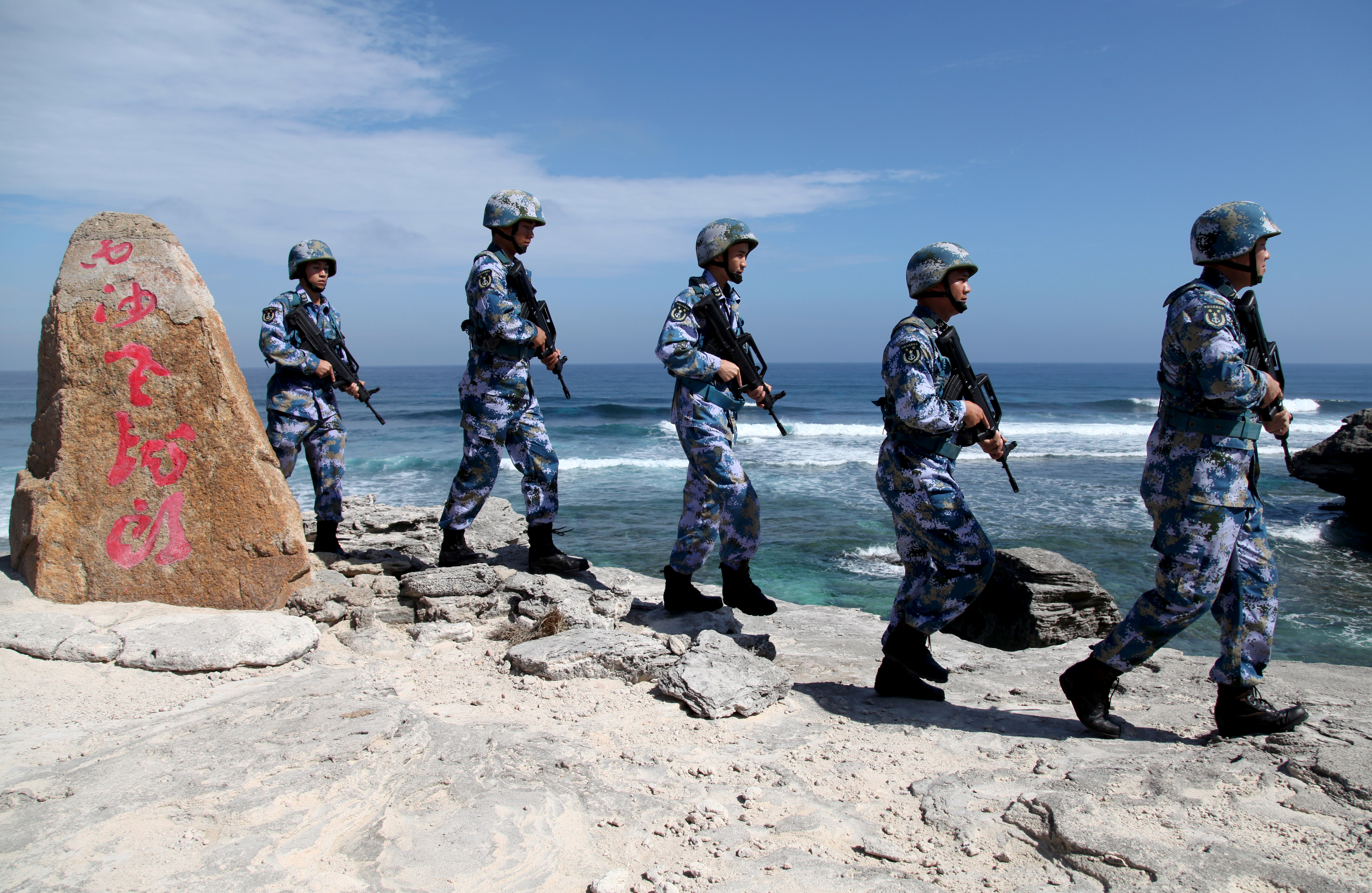 Soldiers of China's People's Liberation Army (PLA) Navy patrol at Woody Island, in the disputed Paracel islands. China plans to hold military exercises in the South China Sea this week [File: Stringer/Reuters]