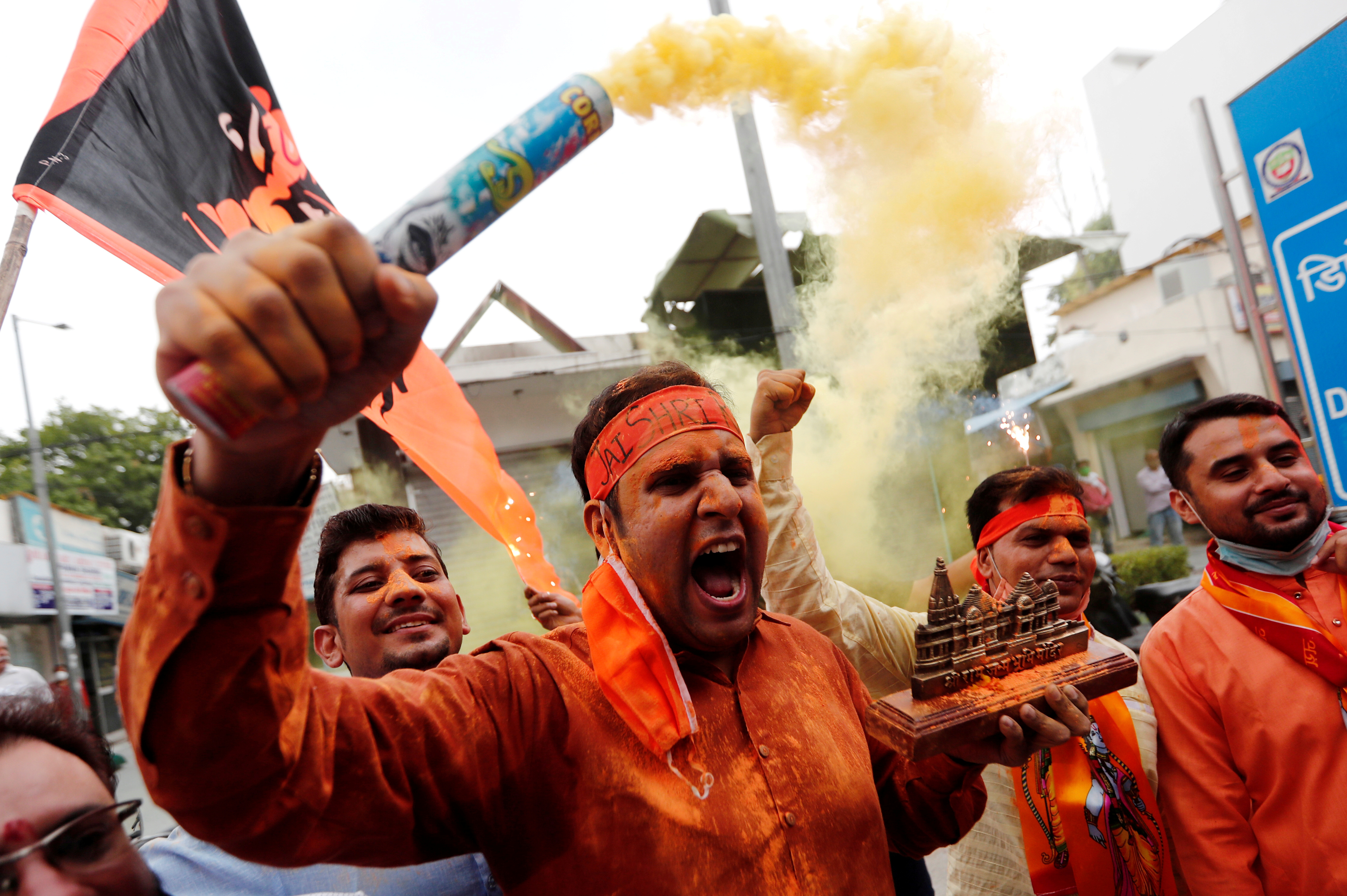 A BJP supporter holds a model of proposed Ram Temple in Ayodhya as they celebrate the laying of its cornerstone in New Delhi last year