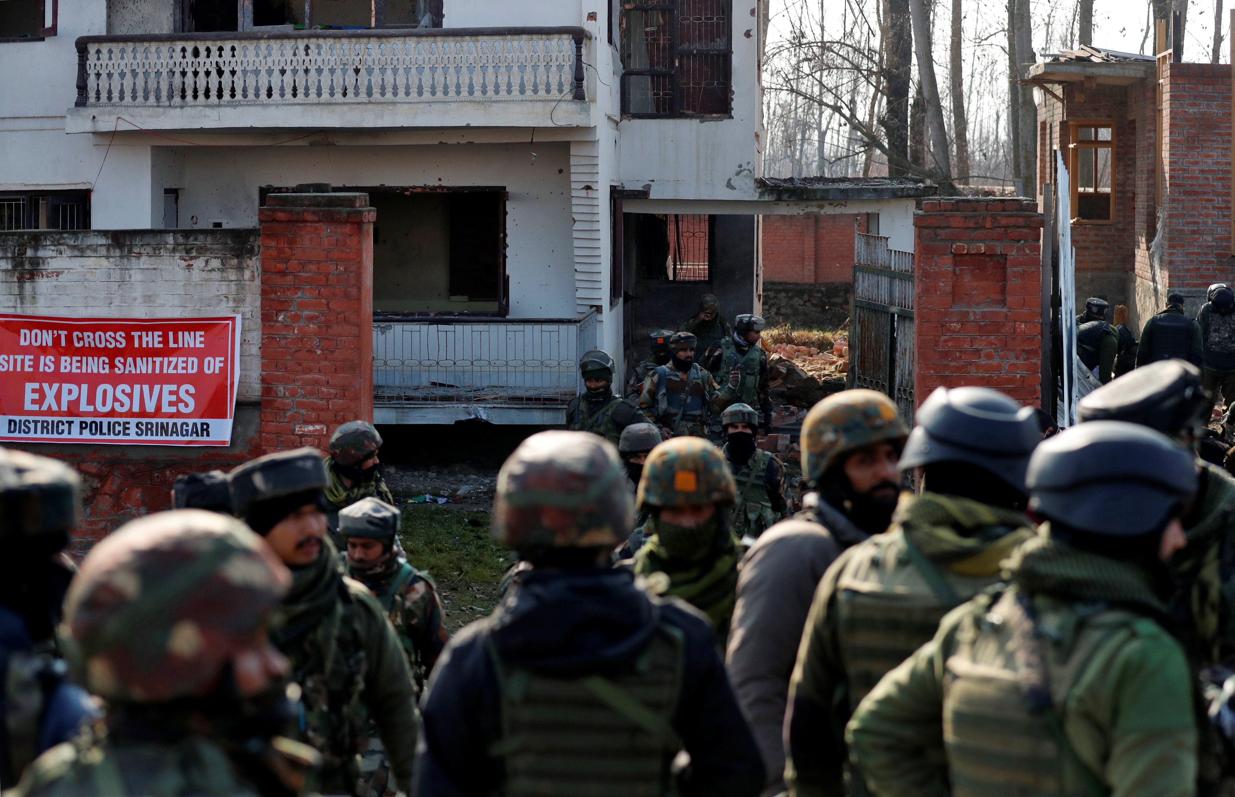 Indian soldiers stand outside a house after a gun battle with suspected rebels on the outskirts of Srinagar on December 30, 2020