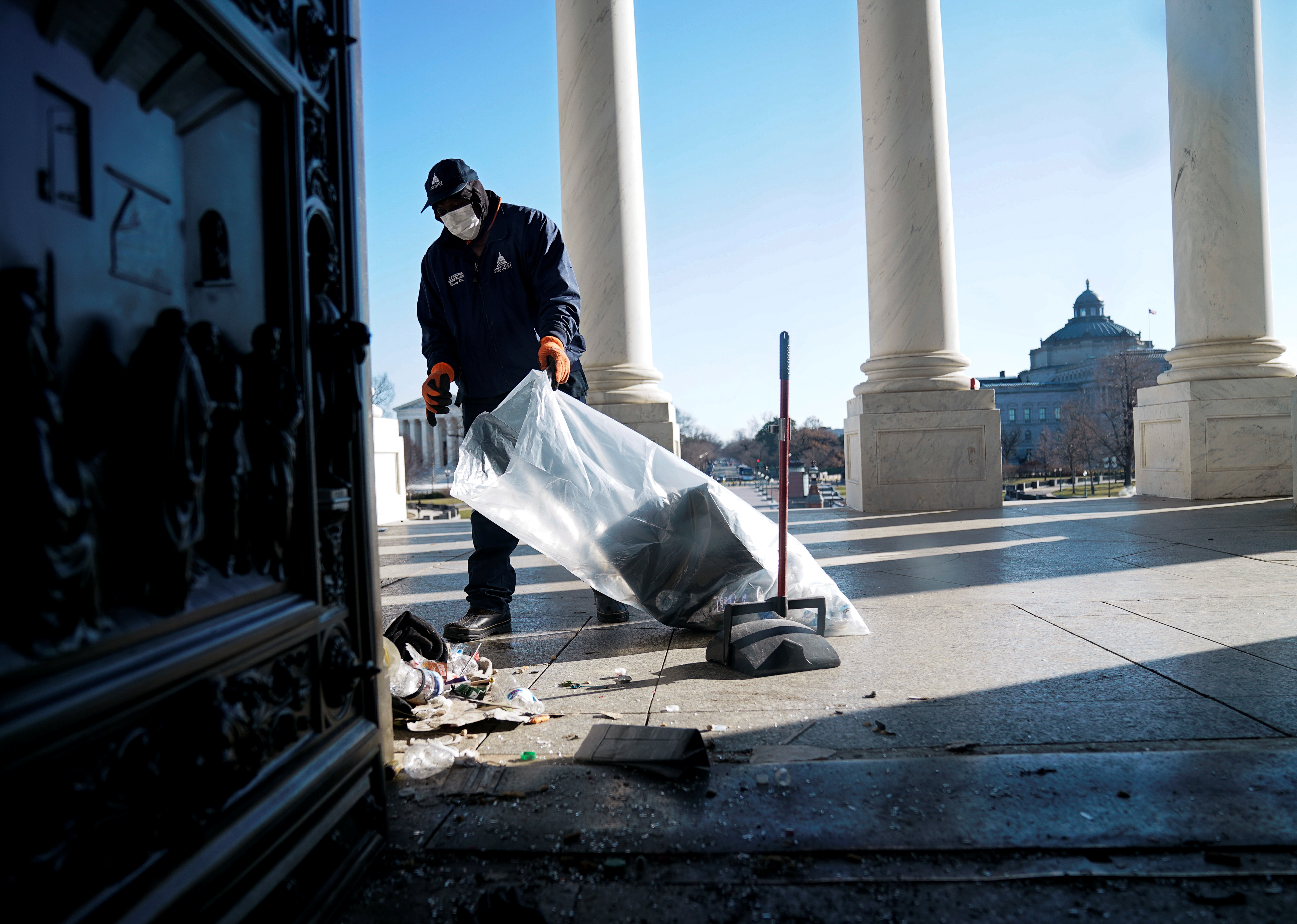 A worker cleaning up debris outside the US Capitol a day after supporters of US President Donald Trump stormed the Capitol in Washington, DC, US