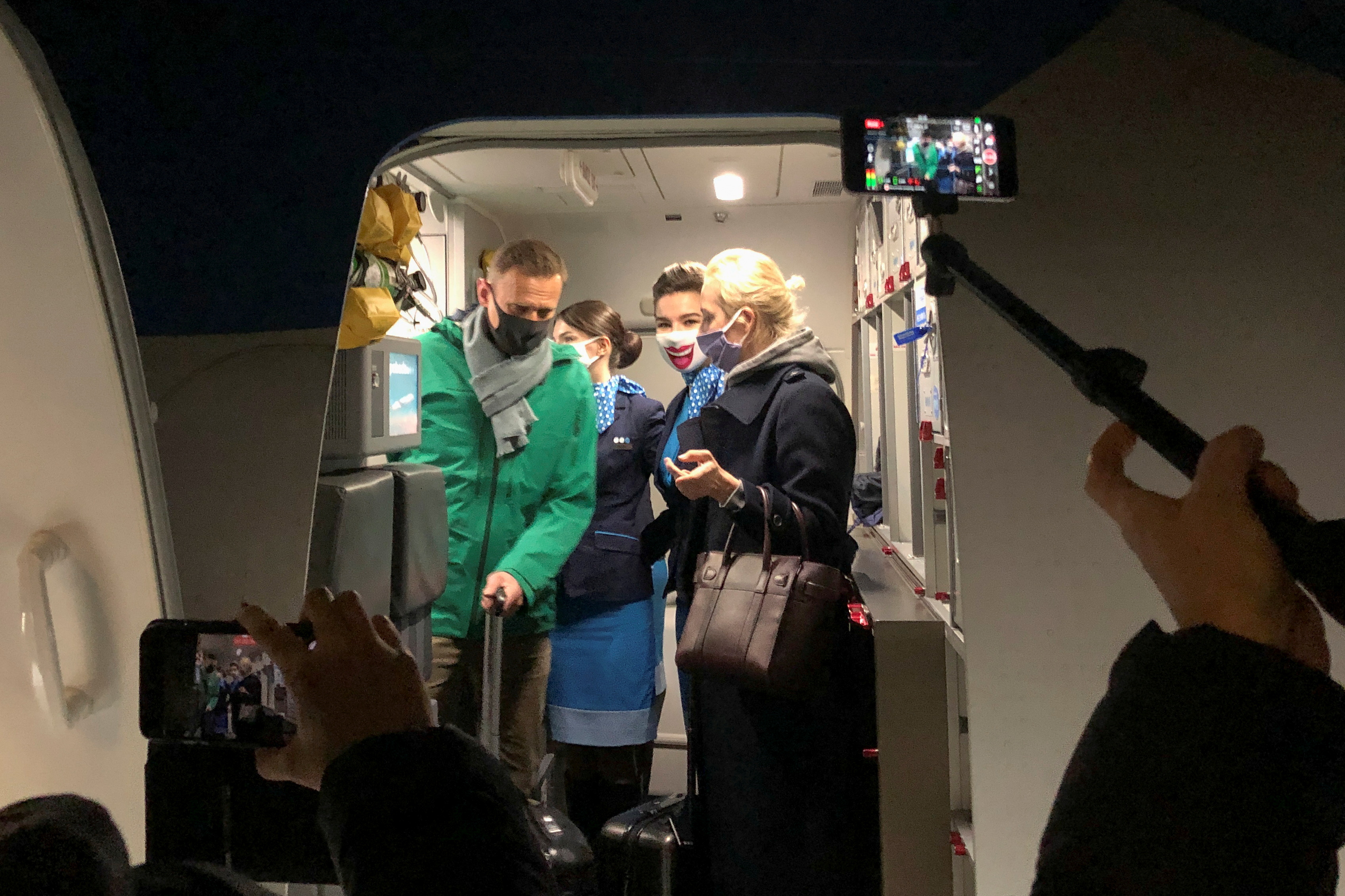 Navalny and his wife Yulia Navalnaya walk out of a plane after arriving at Sheremetyevo airport, Moscow