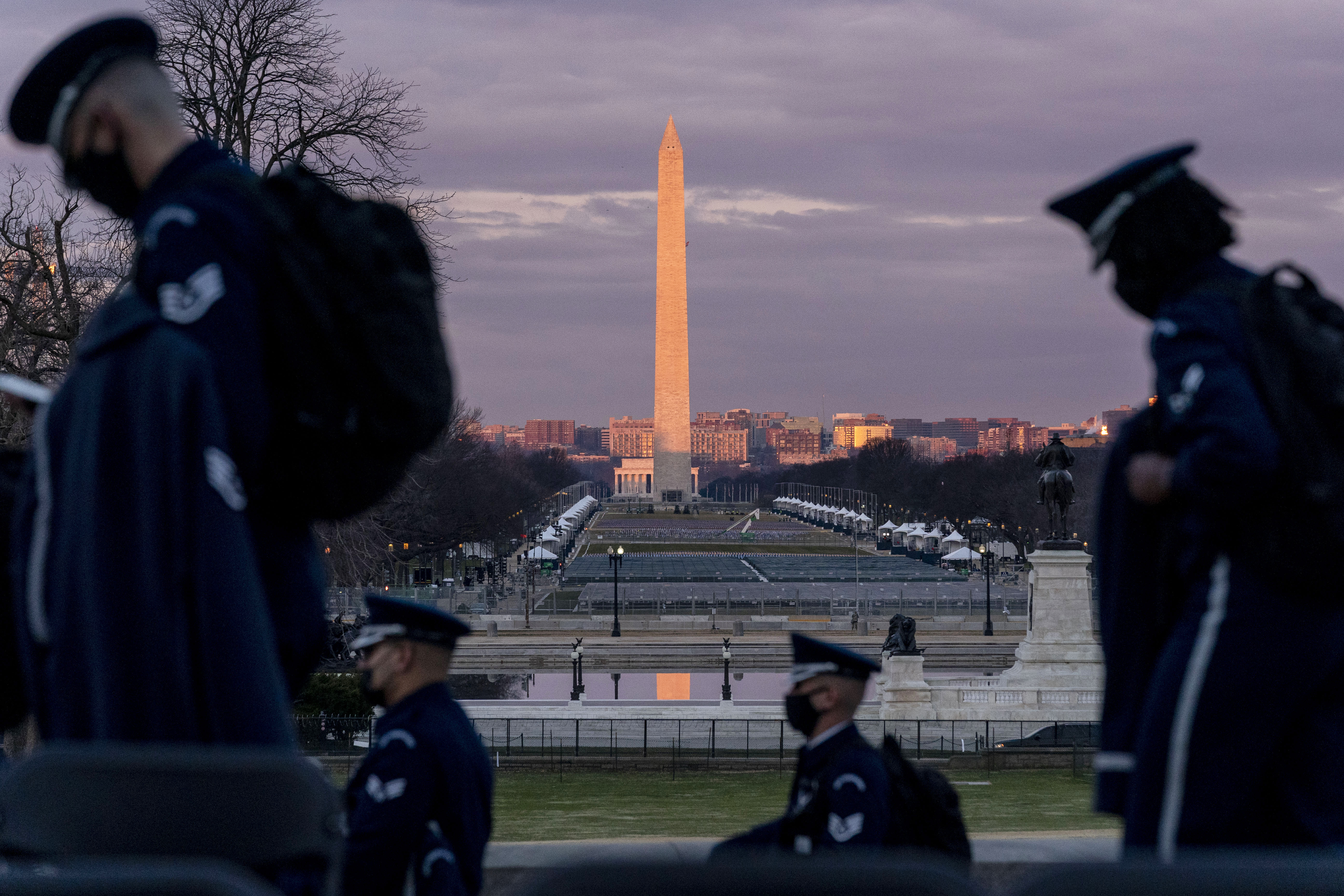 Members of the US Air Force Honor Guard walk in front of the US Capitol, the site where President-elect Joe Biden will be sworn in during the 59th presidential inauguration Wednesday