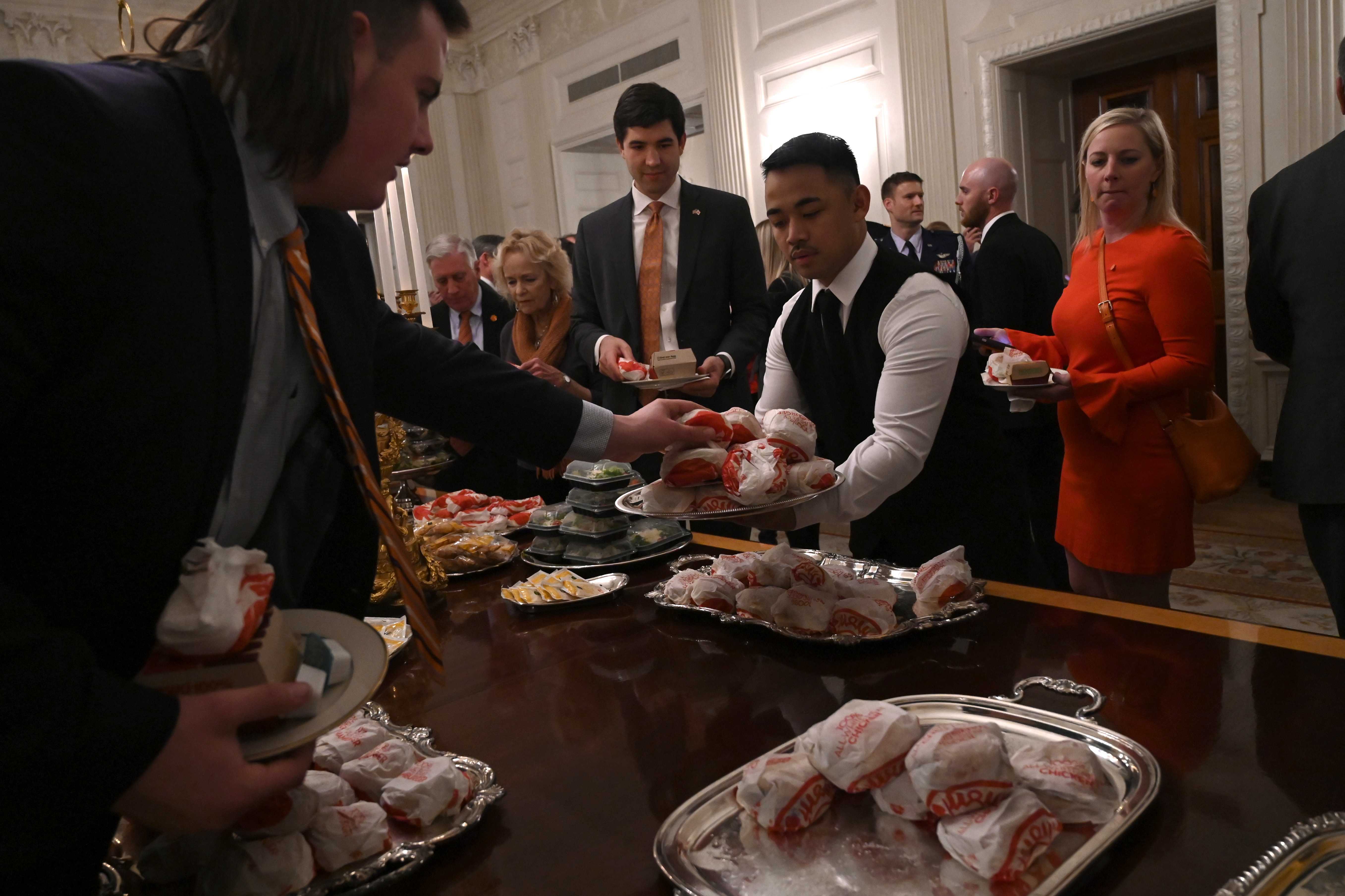 Guests attending a reception for the Clemson Tigers grab fast food sandwiches in the State Dining Room of the White House, January 14, 2019