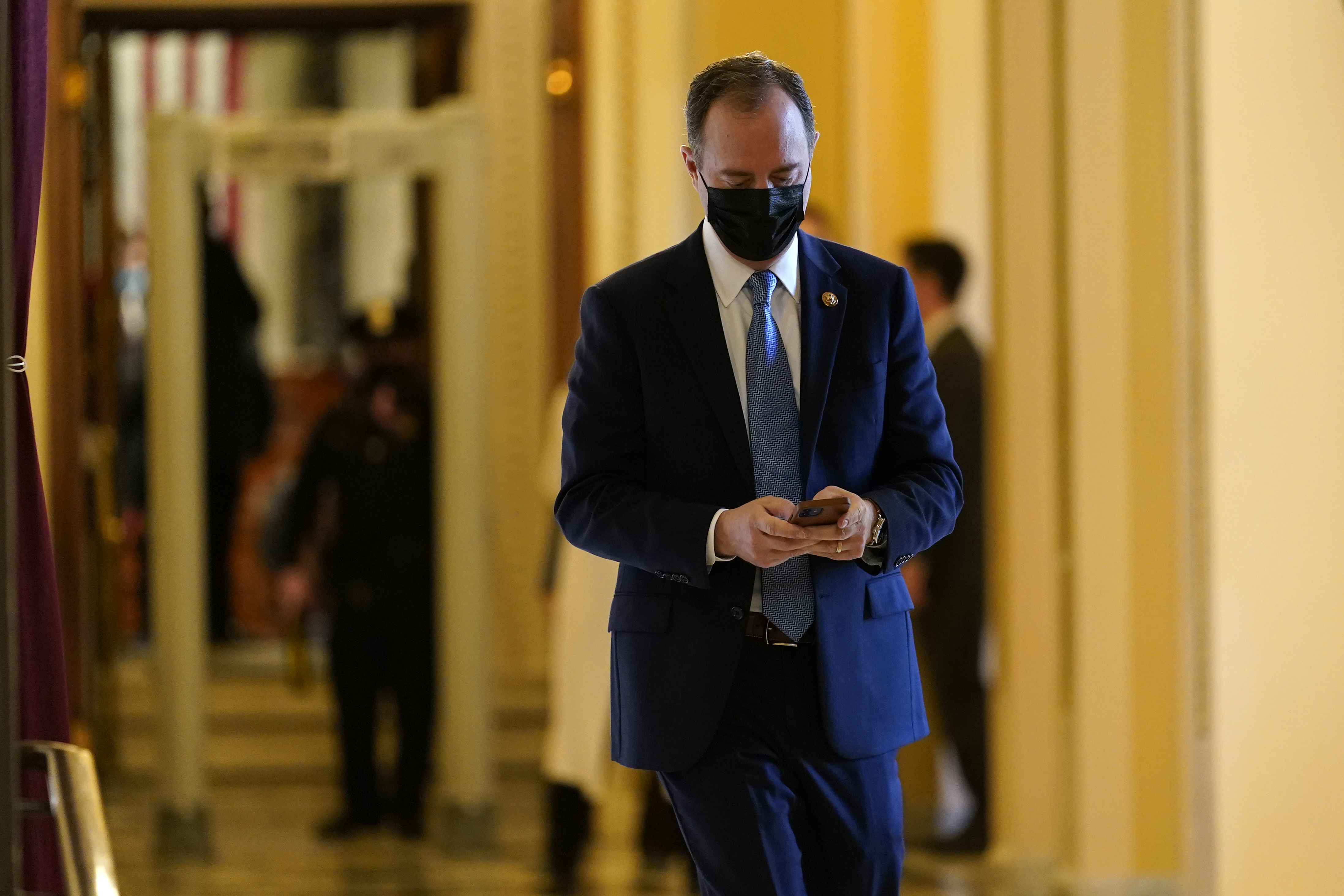 Representative Adam Schiff looks at his phone as he walks on Capitol Hill in Washington