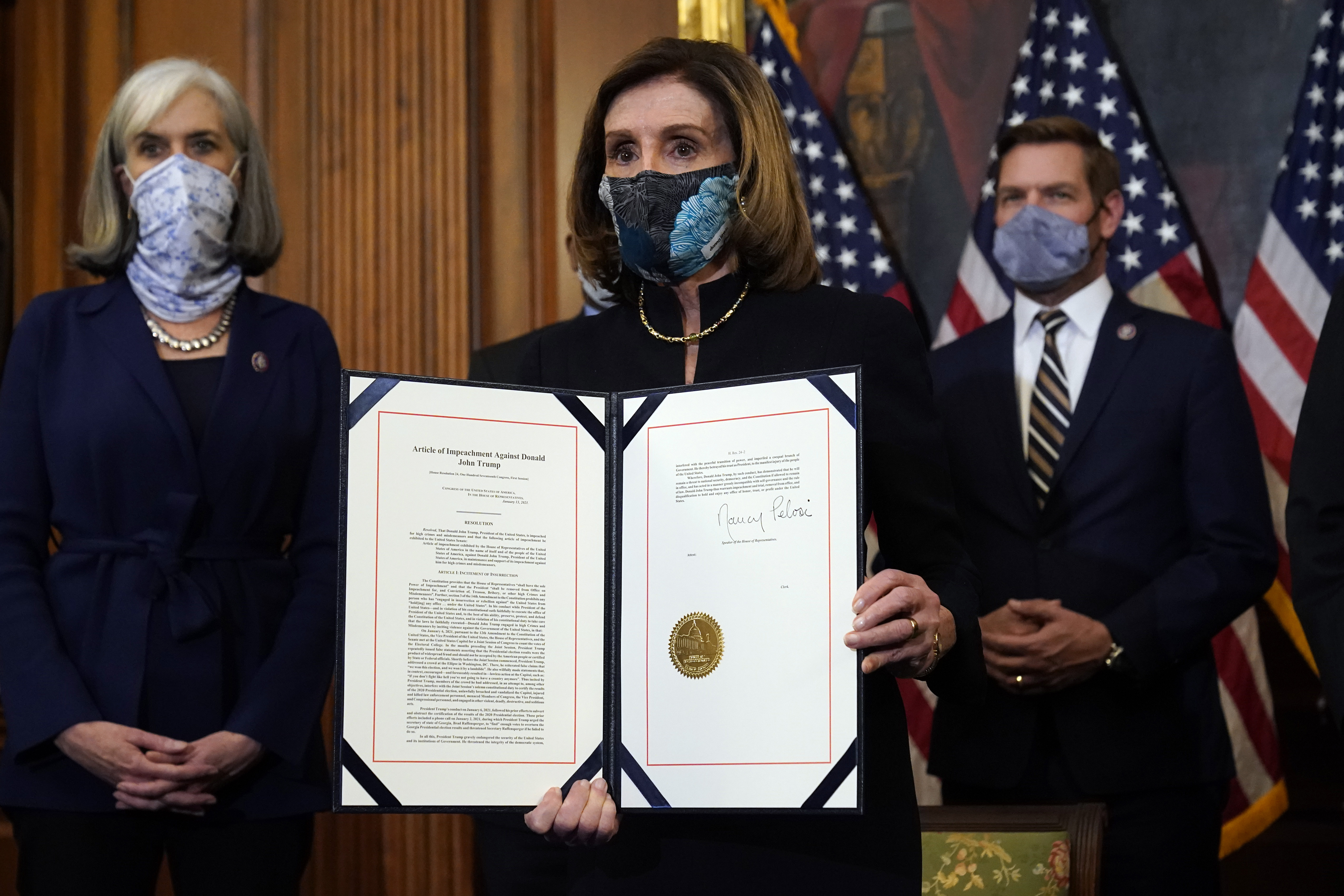 House Speaker Nancy Pelosi displays the signed article of impeachment against President Donald Trump in an engrossment ceremony before transmission to the Senate for trial on Capitol Hill in Washington, DC