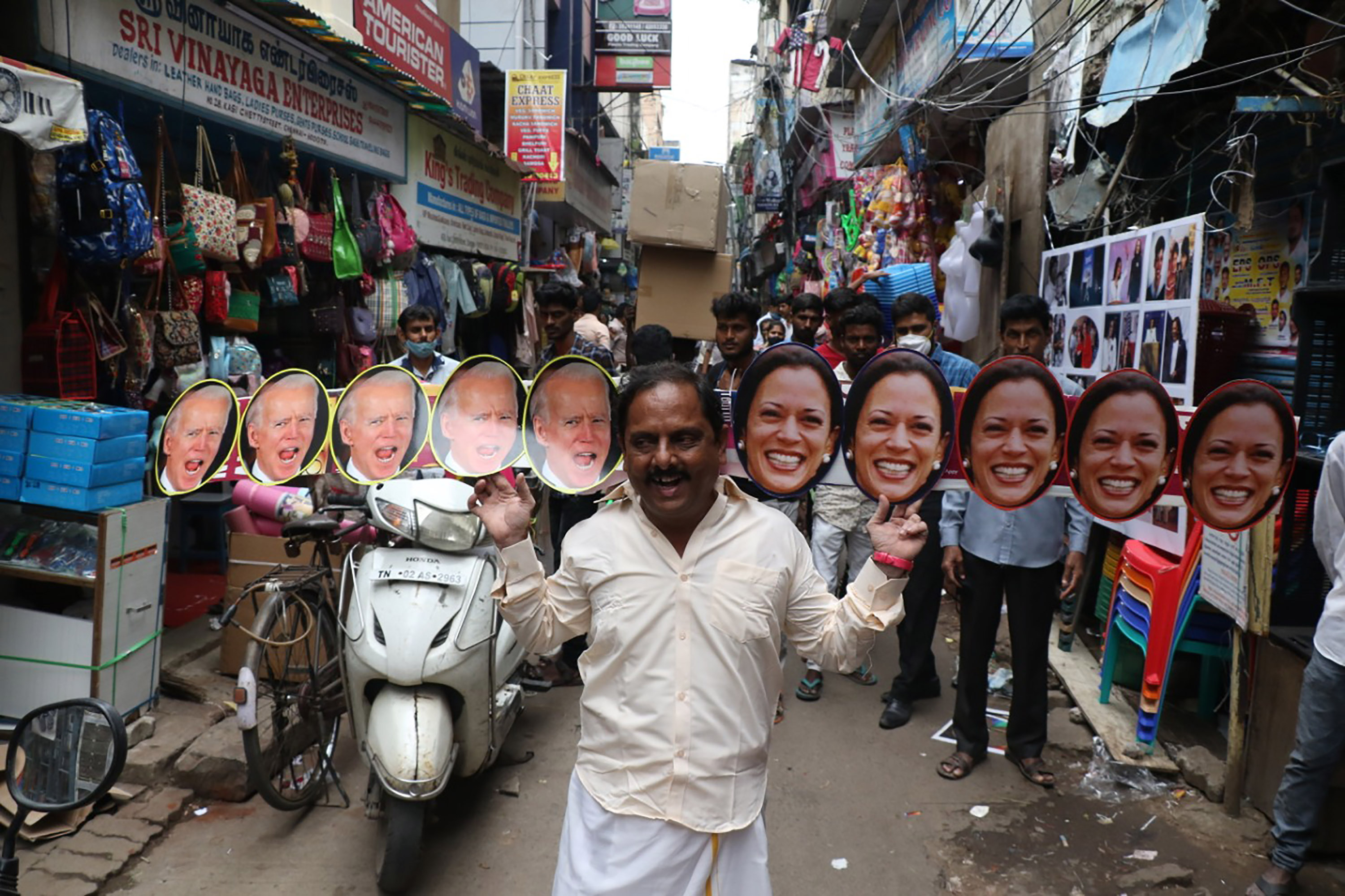 A man wears cut-outs of Biden and Harris on a street in Chennai, India